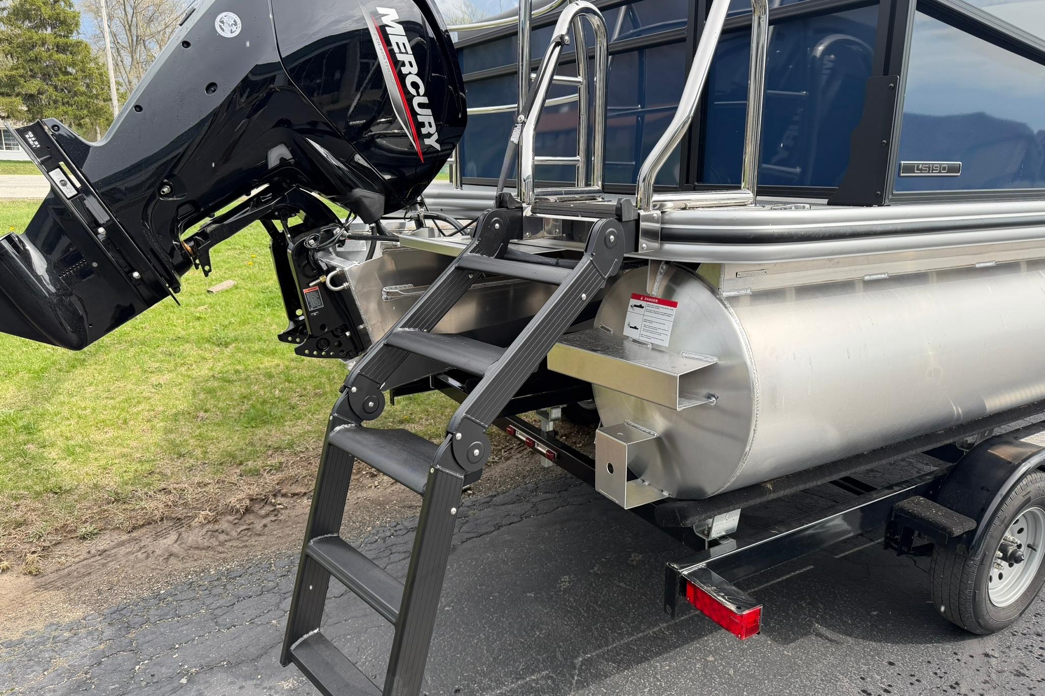 2026 Lowe LS 190 pontoon boat with Mercury outboard motor and boarding ladder.