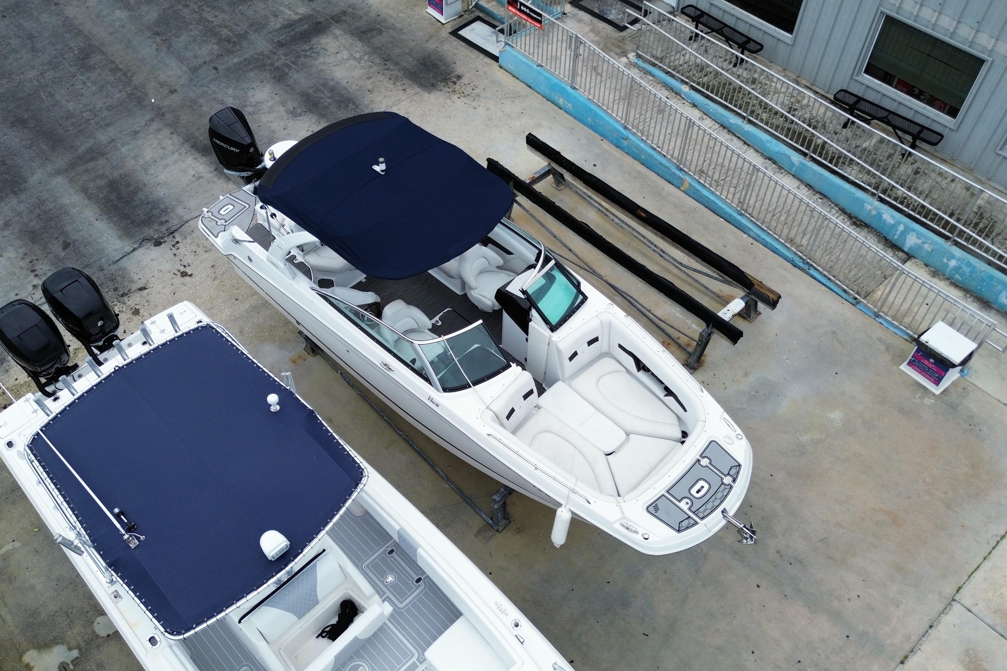 2022 Four Winns HD8 OB boat with navy canopy, docked beside another vessel.