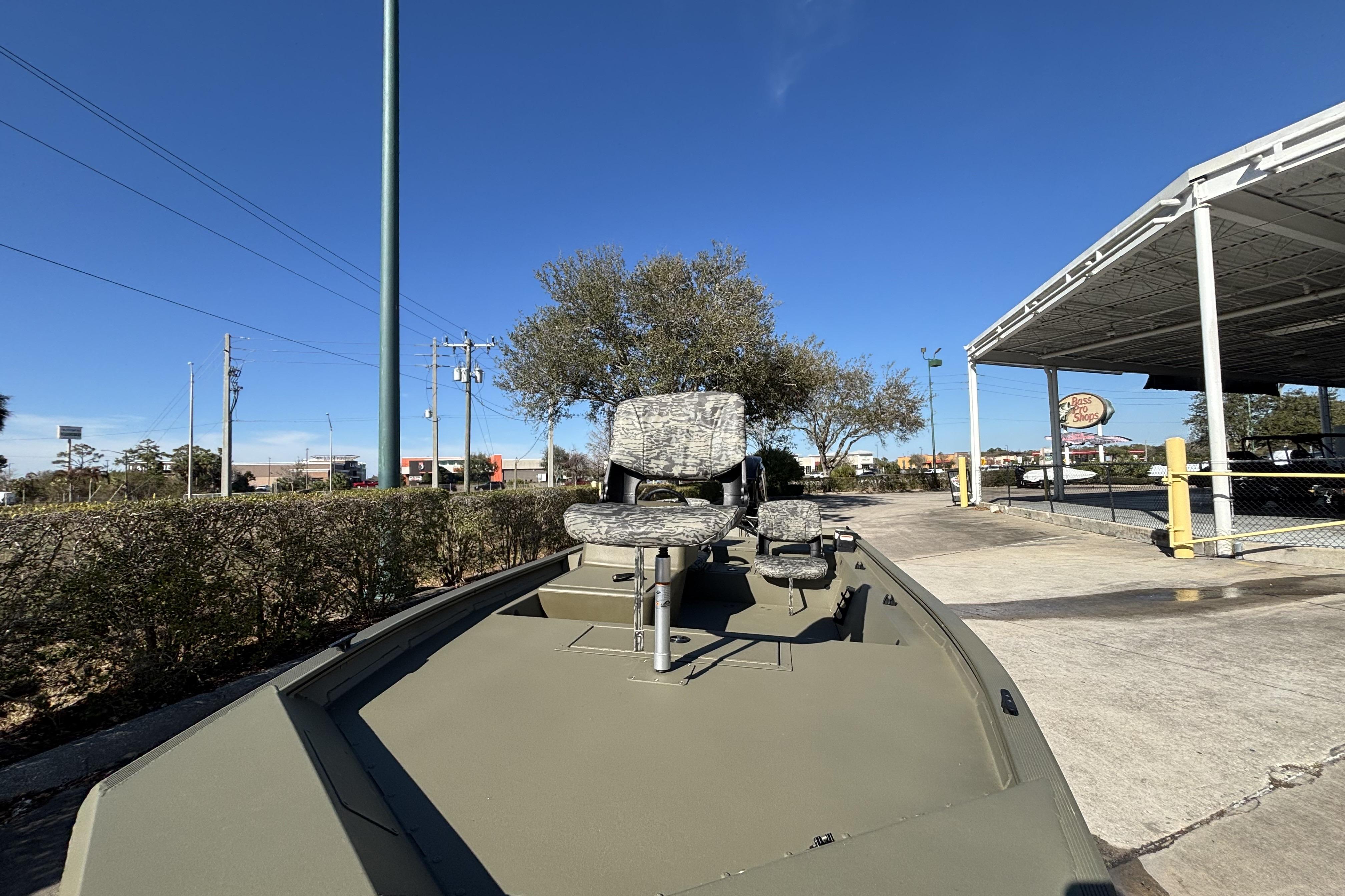 2026 Tracker Grizzly 1754 SC boat with camo seats, parked outdoors.