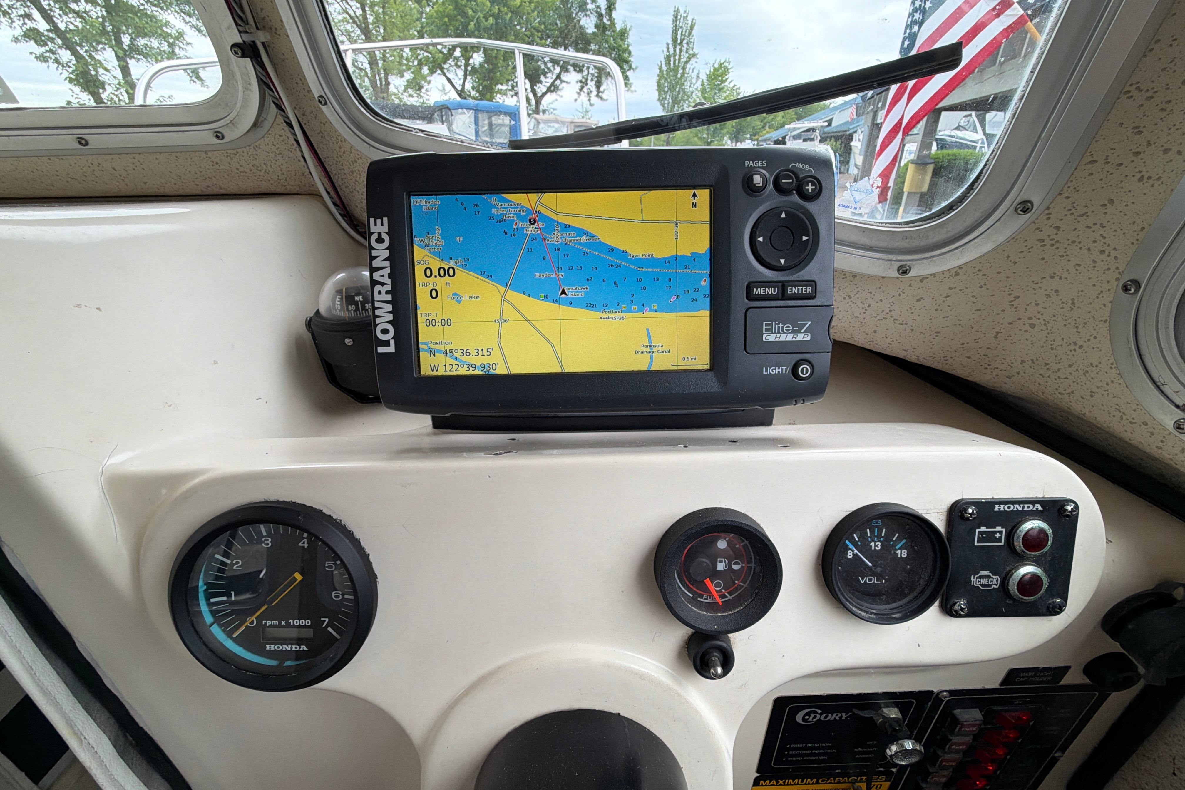 Dashboard of a 1989 C-Dory 22' Angler with navigation system and gauges.