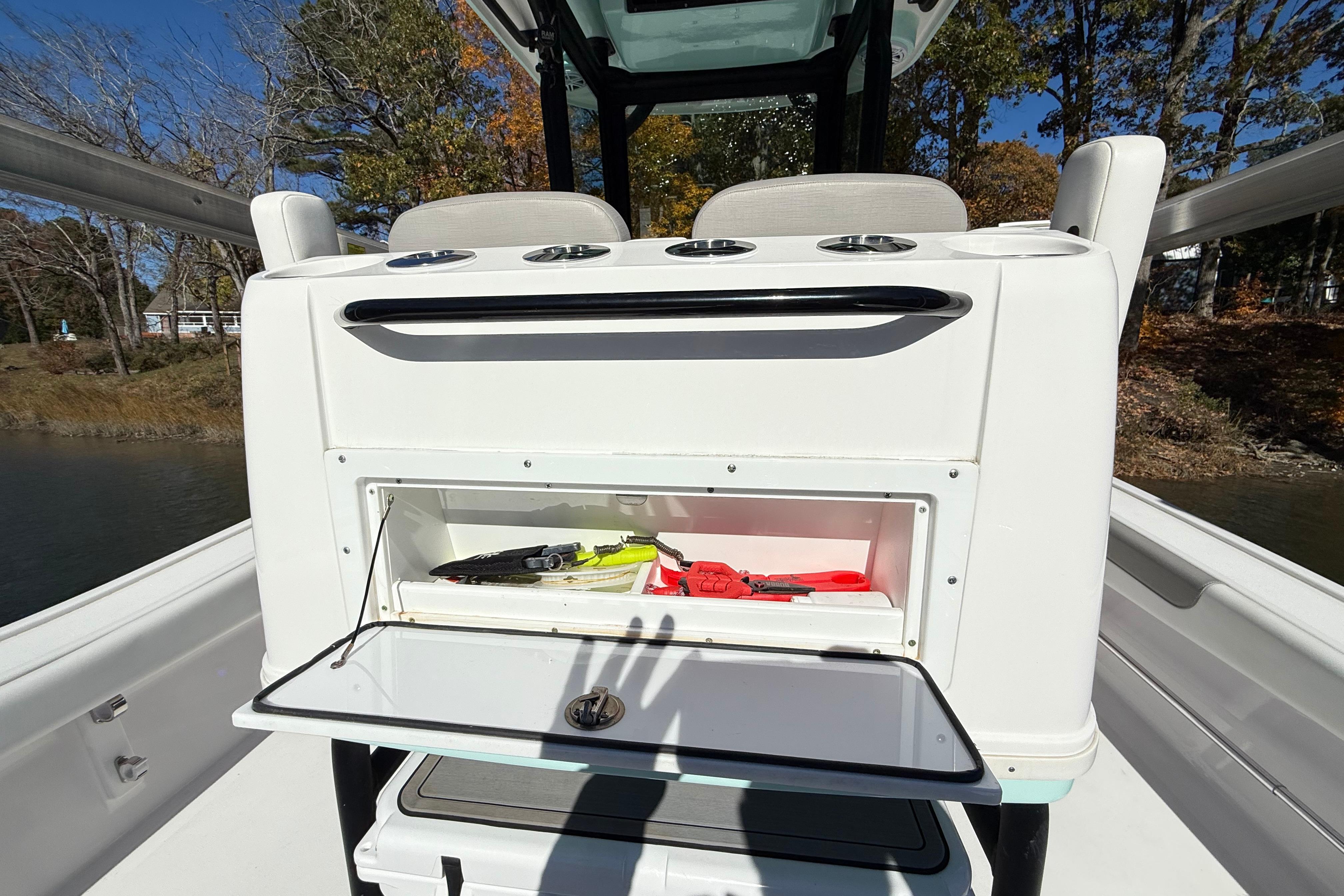 2023 Caymas 281 HB boat with open storage compartment and fishing gear.