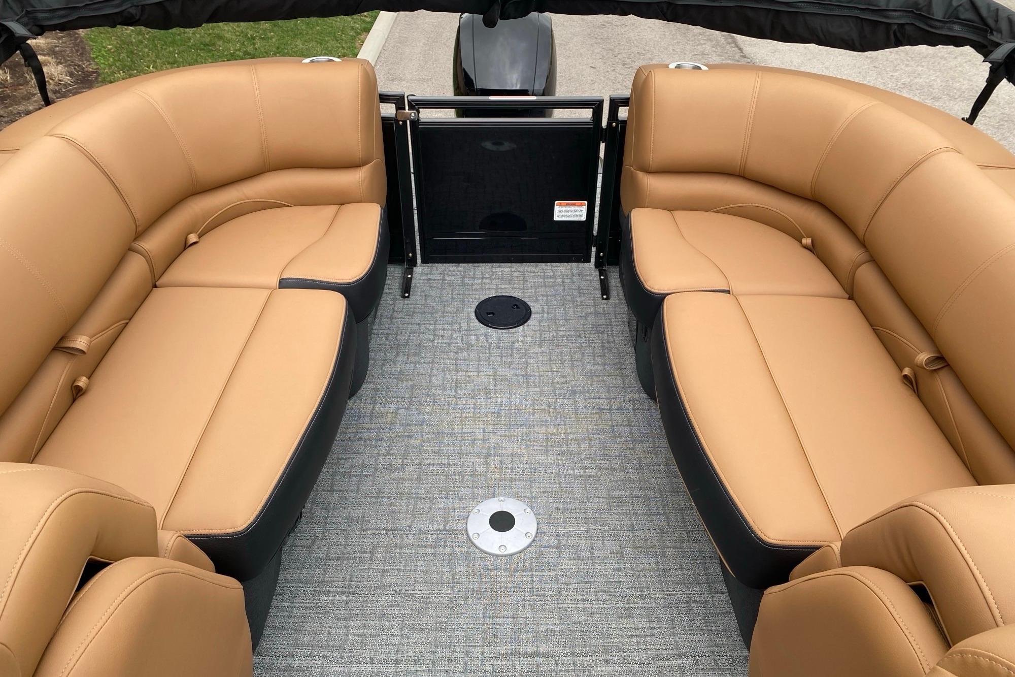 Luxurious seating on 2026 Regency 230 DL pontoon boat with tan upholstery.