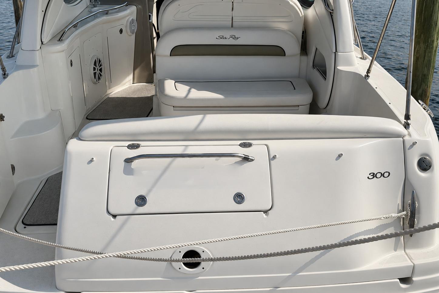 2006 Sea Ray 300 Sundancer boat interior with seating and storage, docked by the water.