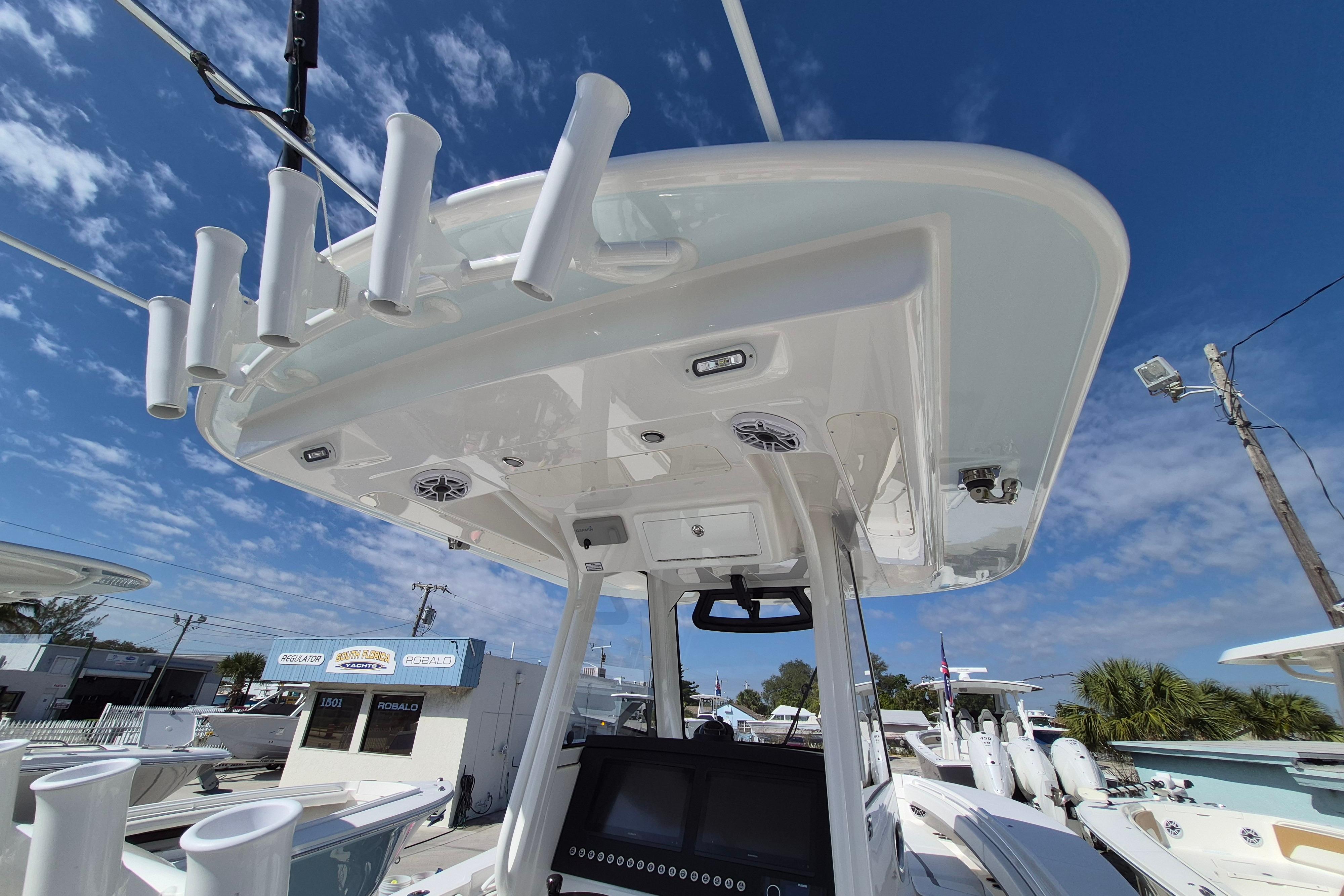2026 Regulator 31 boat with rod holders and electronics under a clear blue sky.
