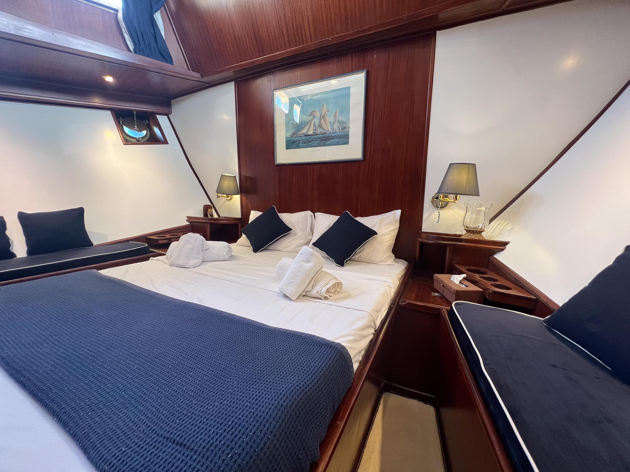 Luxurious cabin interior of 1969 Psarros Shipyard yacht with elegant bedding and decor.