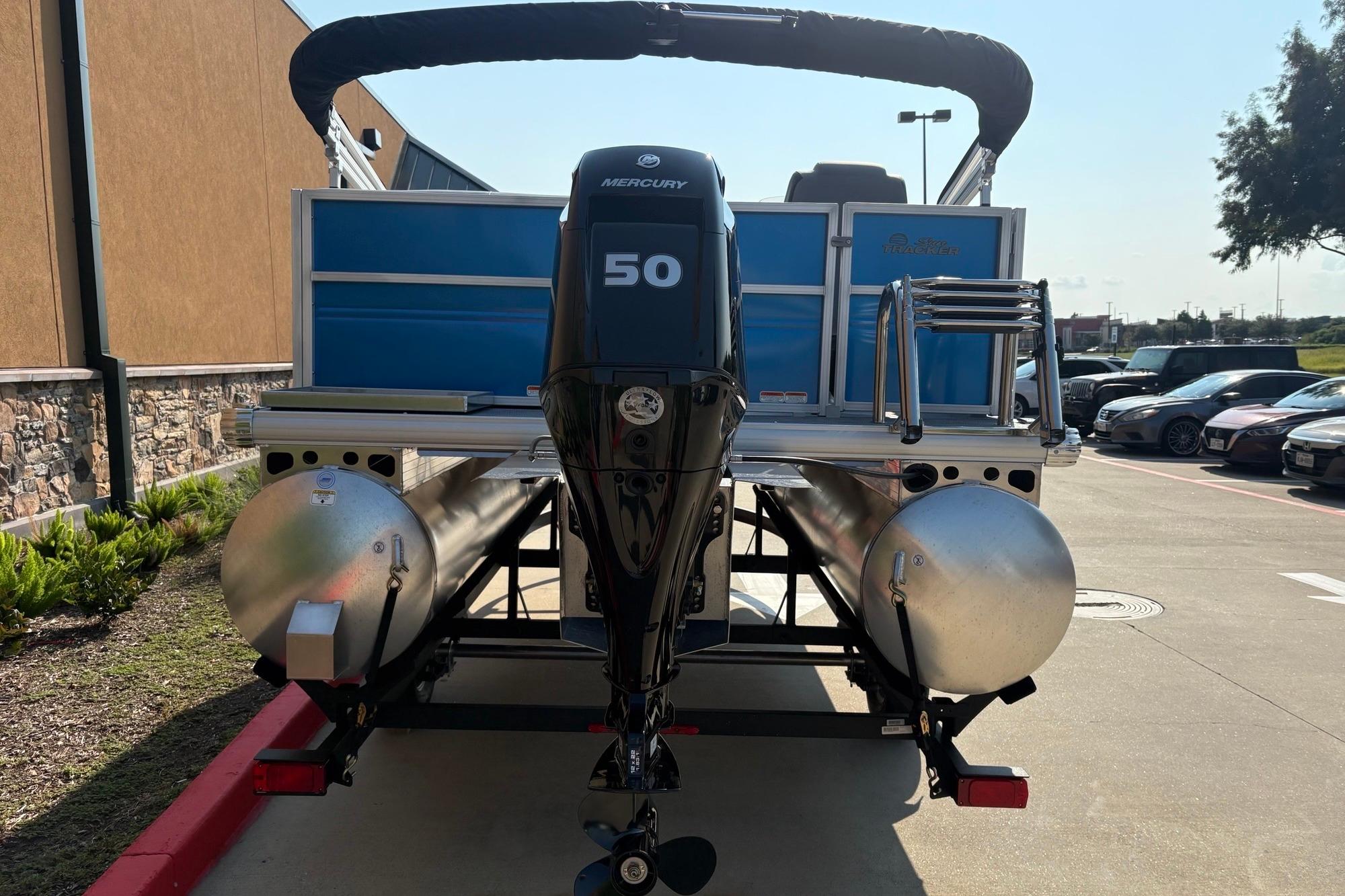 2026 Sun Tracker Party Barge 16 DLX pontoon boat with Mercury 50 engine, parked outdoors.