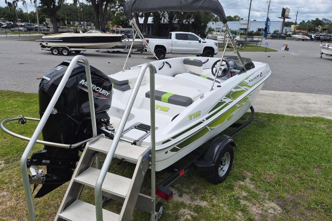 2021 Tahoe T16 boat with Mercury engine on trailer, parked outdoors.