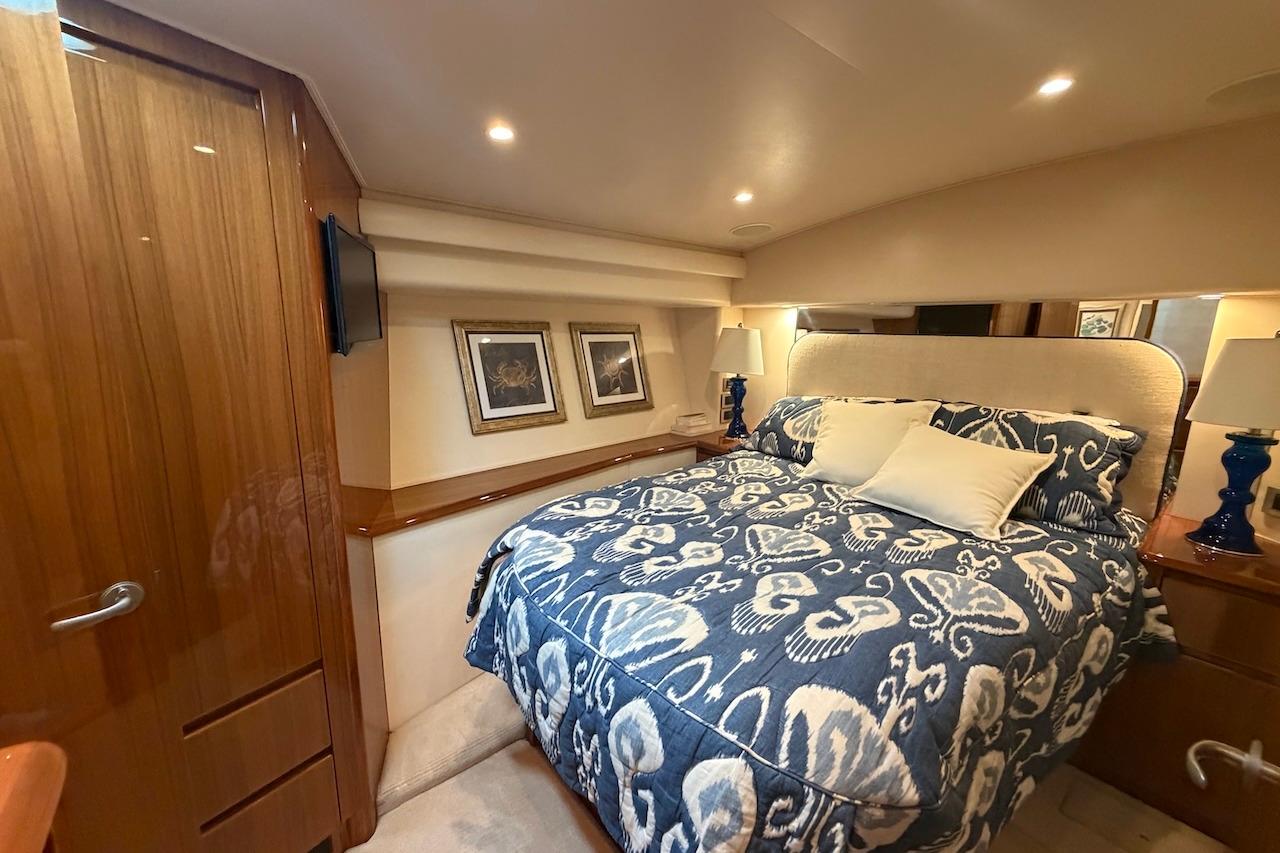 Luxurious bedroom interior of 2012 Viking 50 Convertible yacht with elegant bedding and decor.