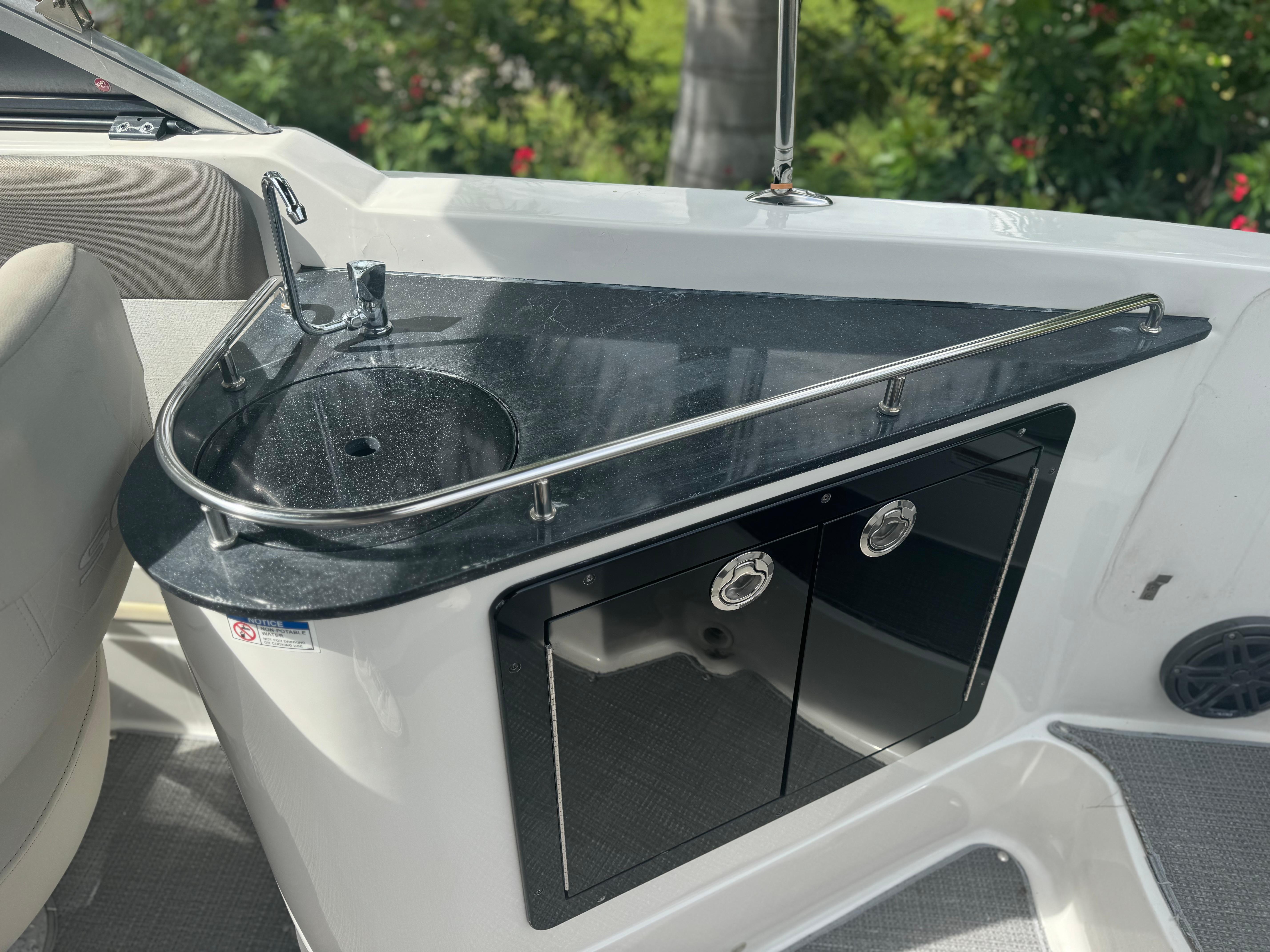 2017 Starcraft 230 OB SCX EXT boat sink and counter with storage cabinets.