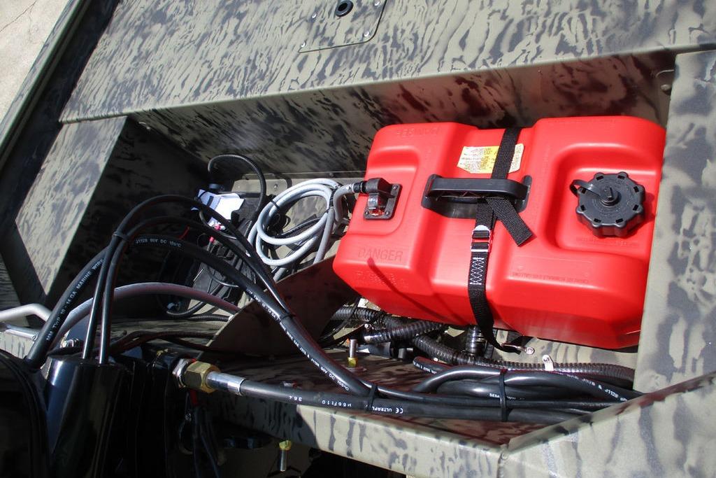 2026 Tracker GRIZZLY® 1648 SC boat storage with red fuel tank and cables.