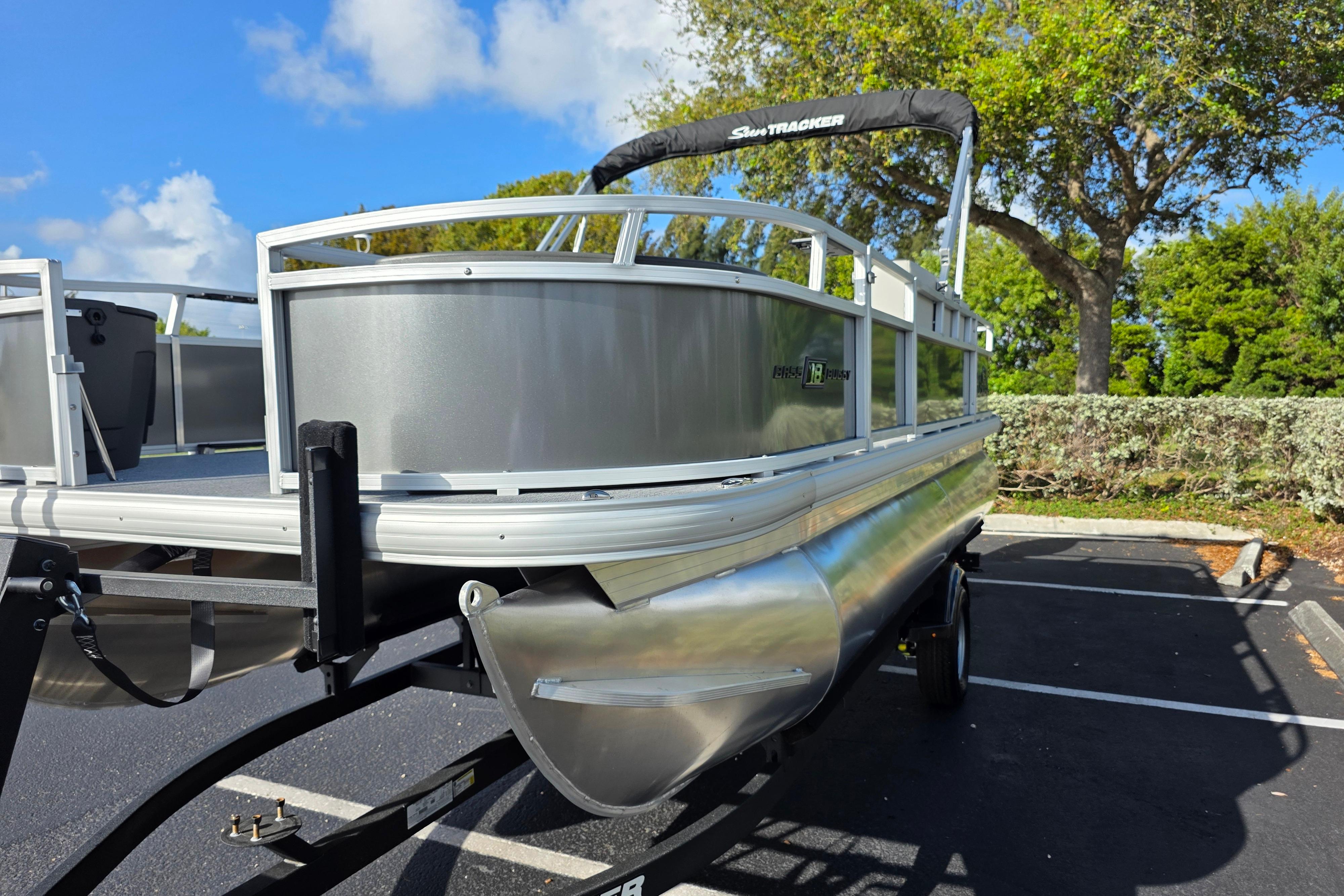 2026 Sun Tracker Bass Buggy 16 XL Select pontoon boat in parking lot.