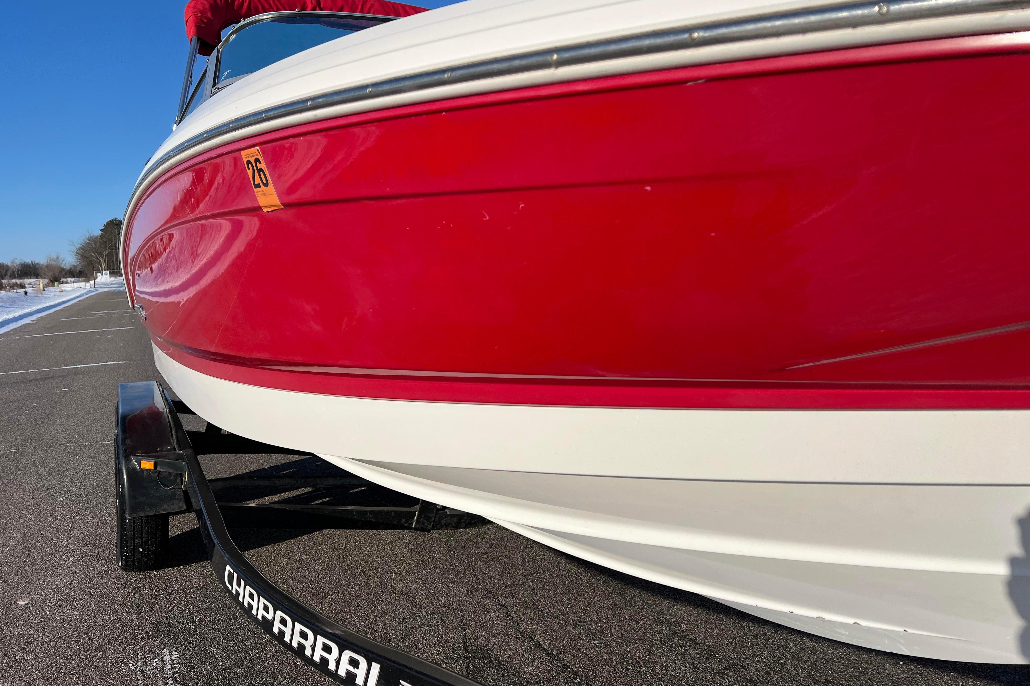 2010 Chaparral 216 SSi boat with red and white exterior on a trailer.