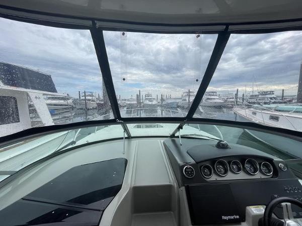 View from the helm of a 2014 Sea Ray 310 Sundancer at a marina.