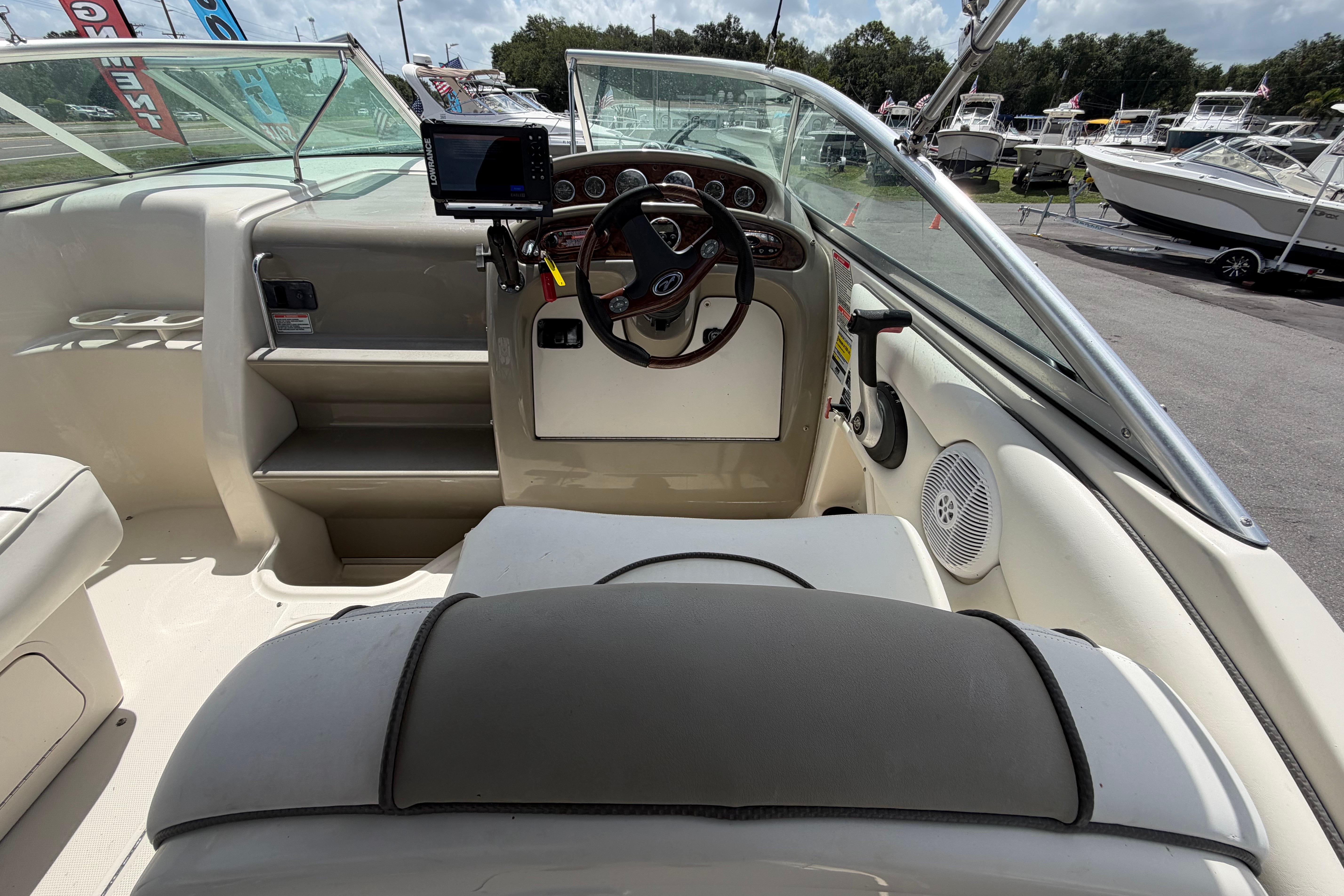 Interior view of 2006 Sea Ray 250 Amberjack boat cockpit with steering wheel and controls.