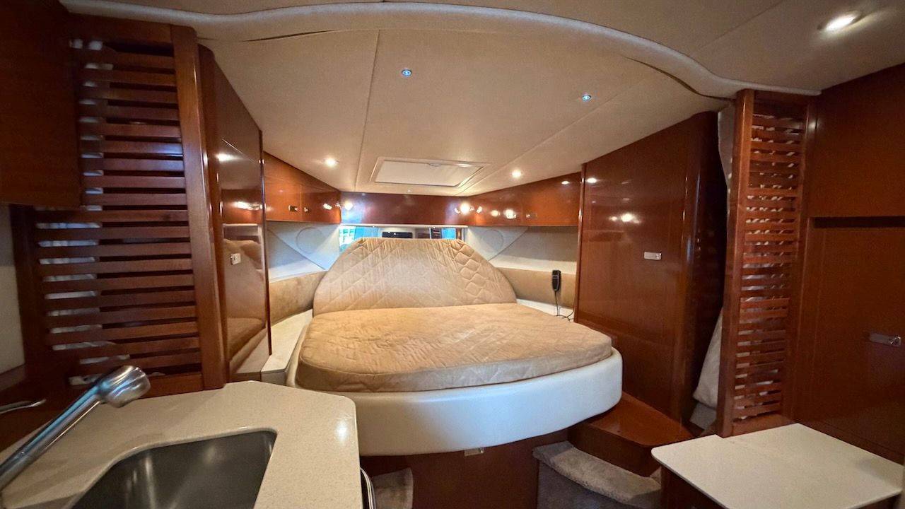 Interior of the 2011 Sea Ray Sundancer 370 with cozy bed and wood accents.