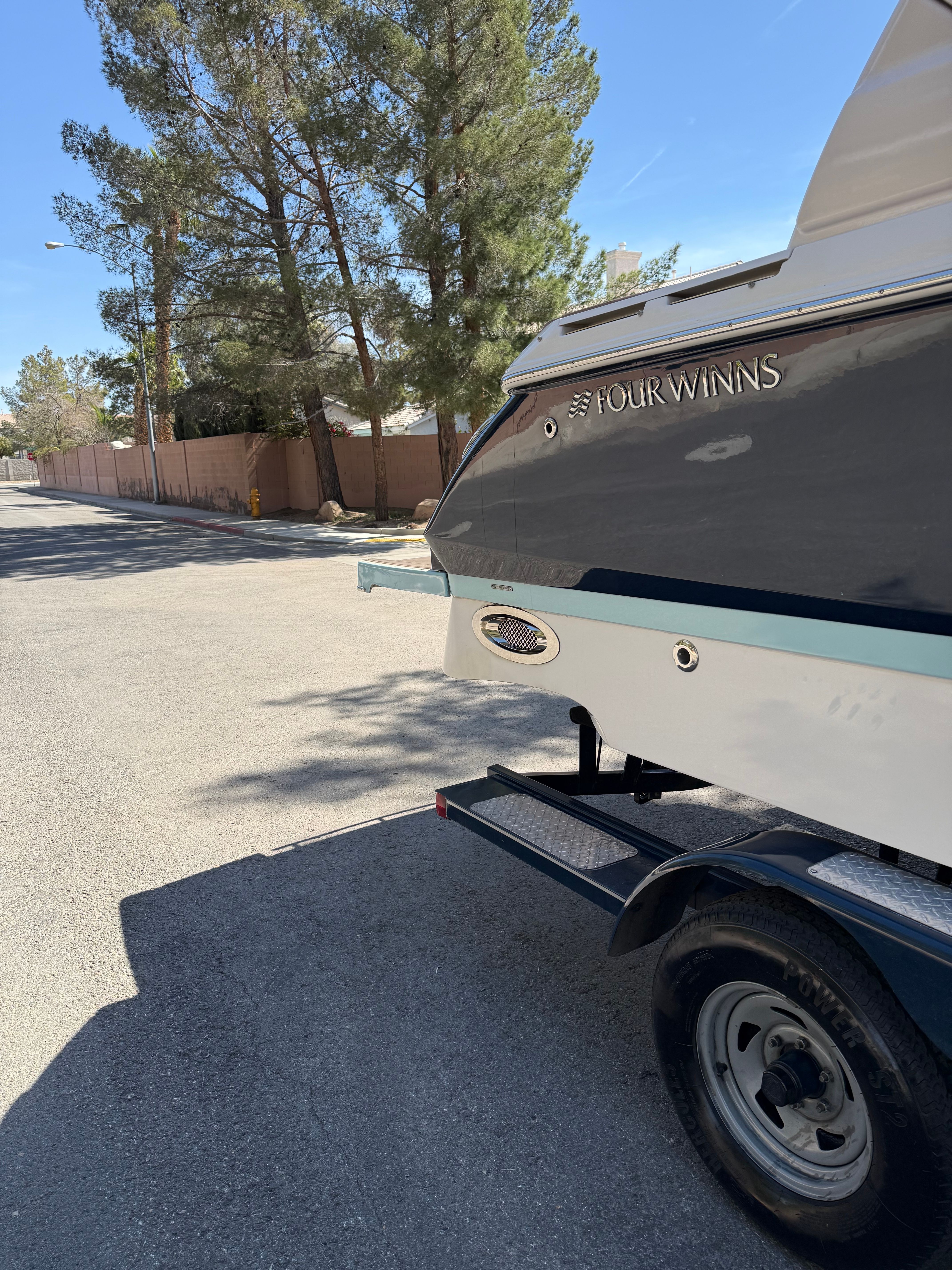2019 Four Winns H260 boat on trailer, sunny day.