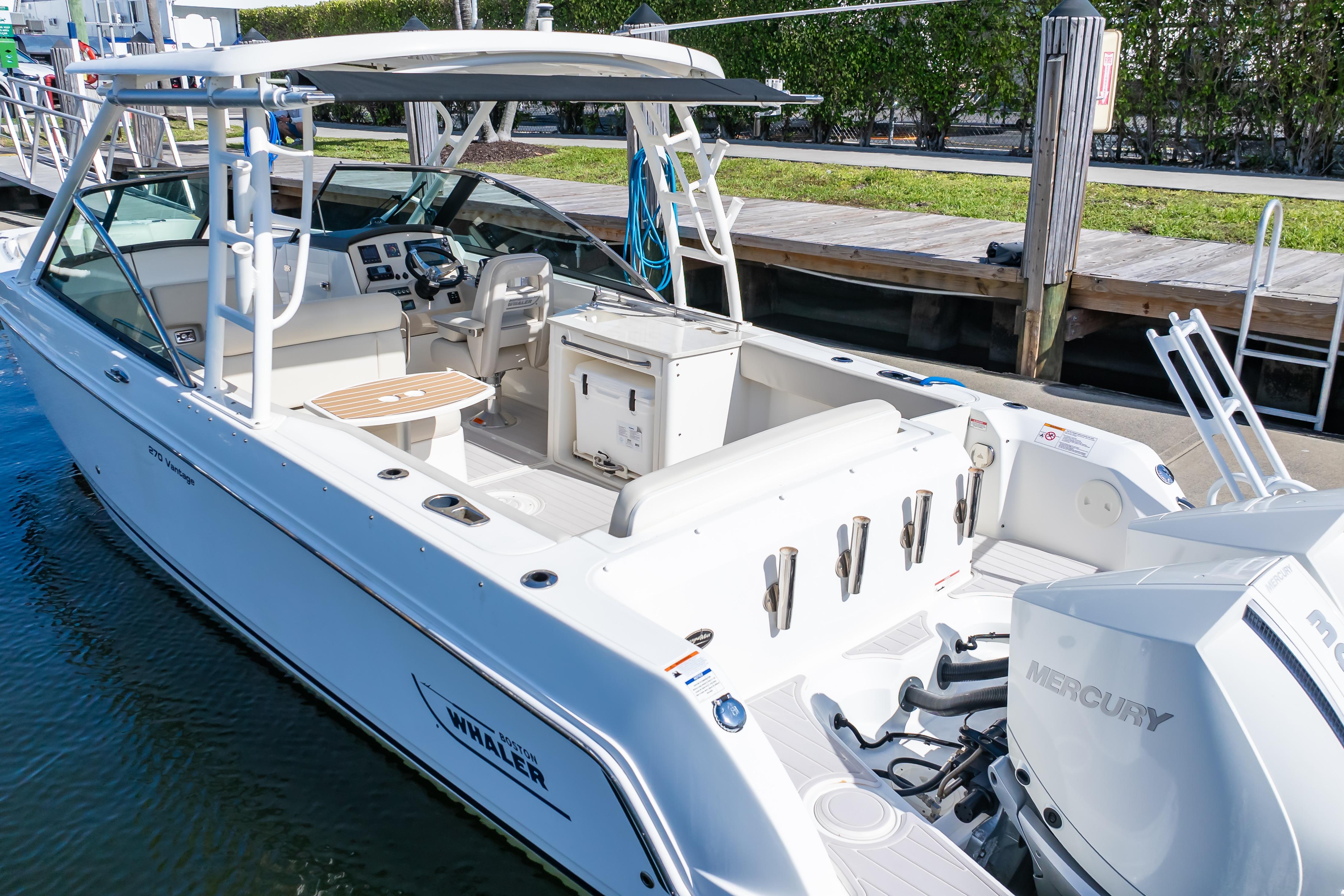 2019 Boston Whaler 270 Vantage boat docked, featuring spacious seating and dual Mercury engines.