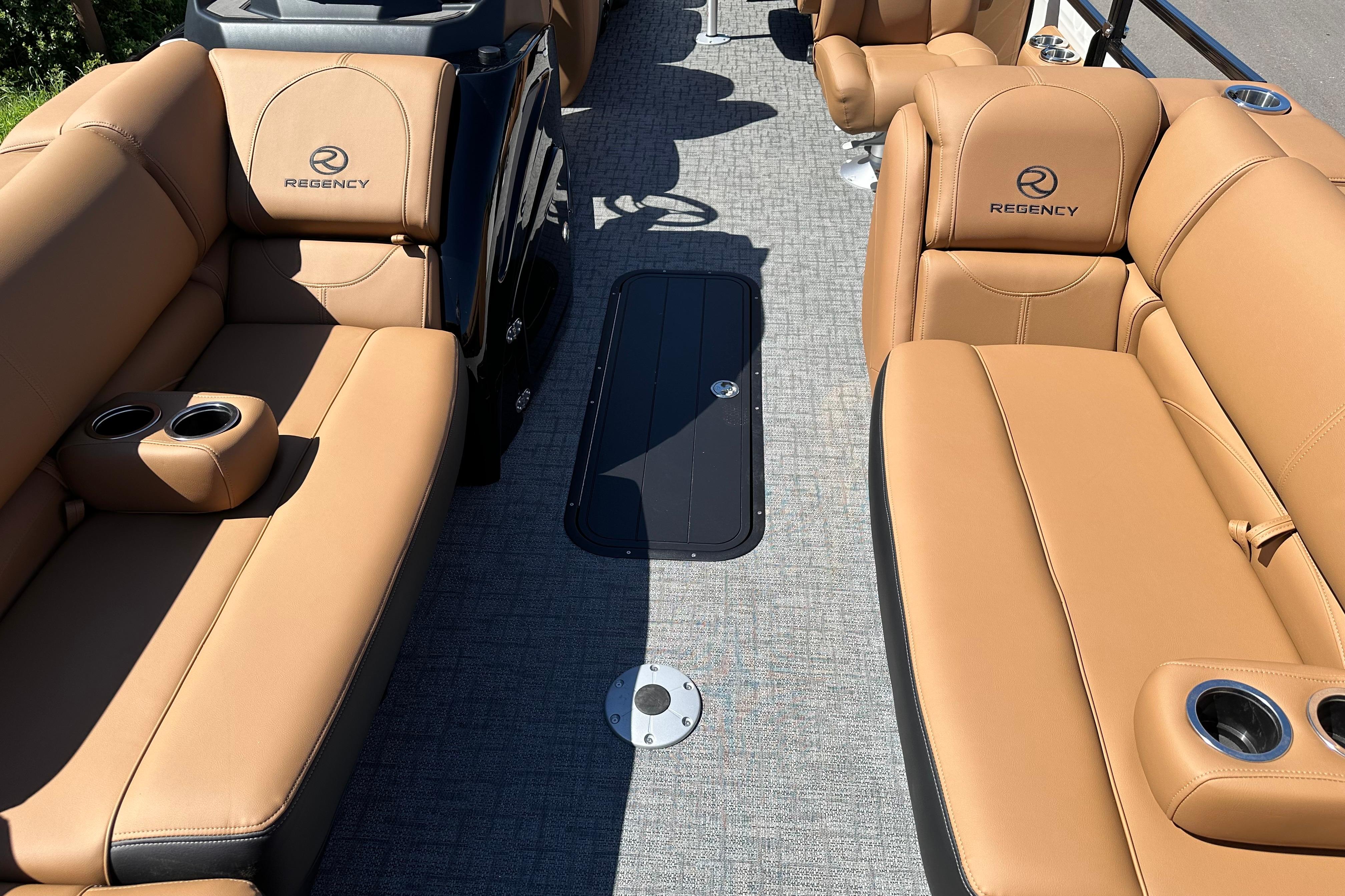 Luxurious interior of 2026 Regency 230 DL boat with tan leather seating and cup holders.