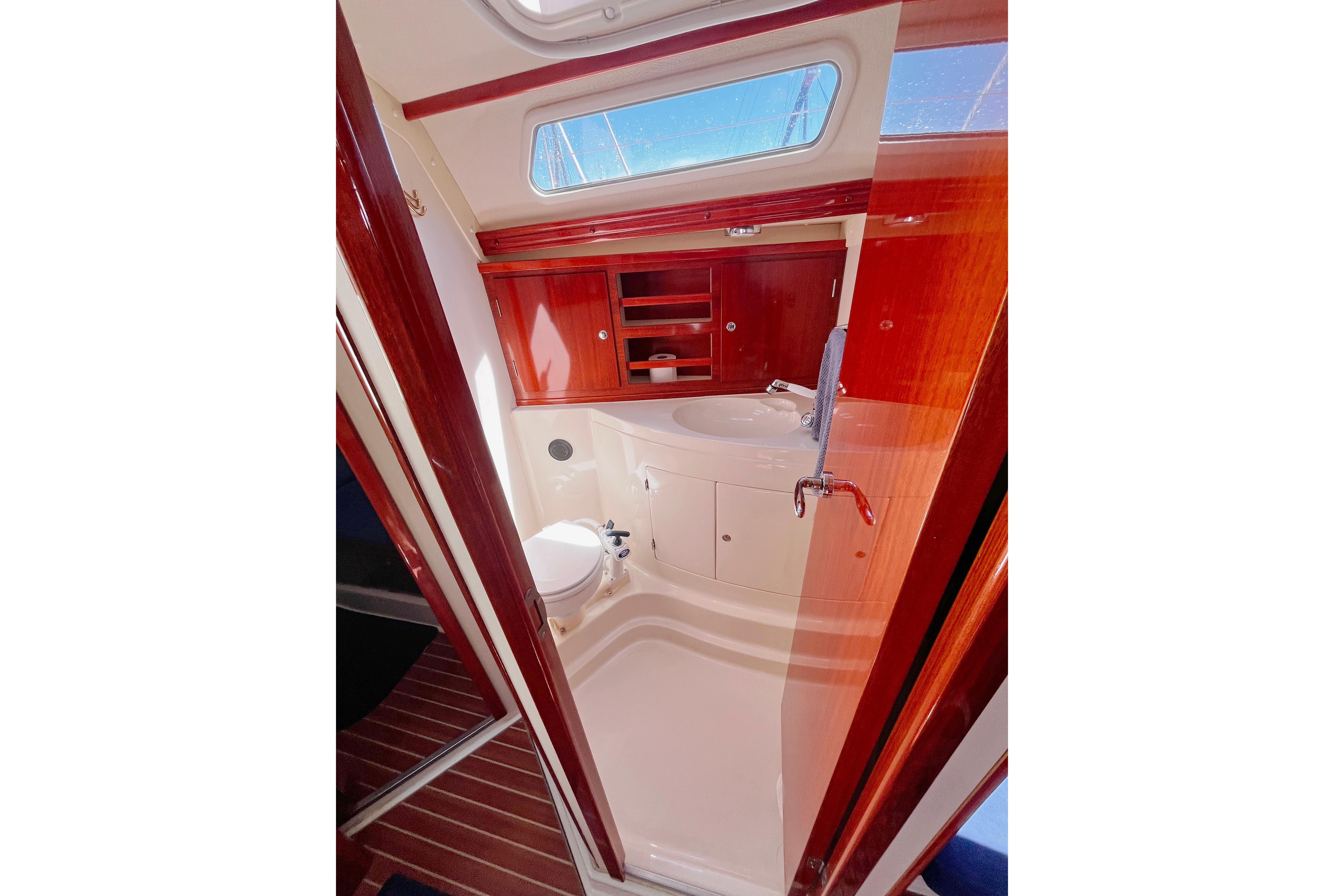 Luxurious bathroom interior of 2004 Hanse 411 yacht with wooden cabinetry and modern fixtures.