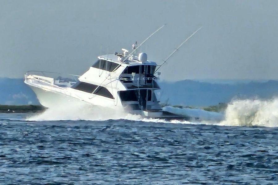 2002 Viking 61 Enclosed Bridge yacht cruising on open water.