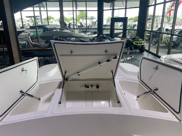 2024 Mako Pro Skiff 19 CC boat with open storage compartments in showroom.