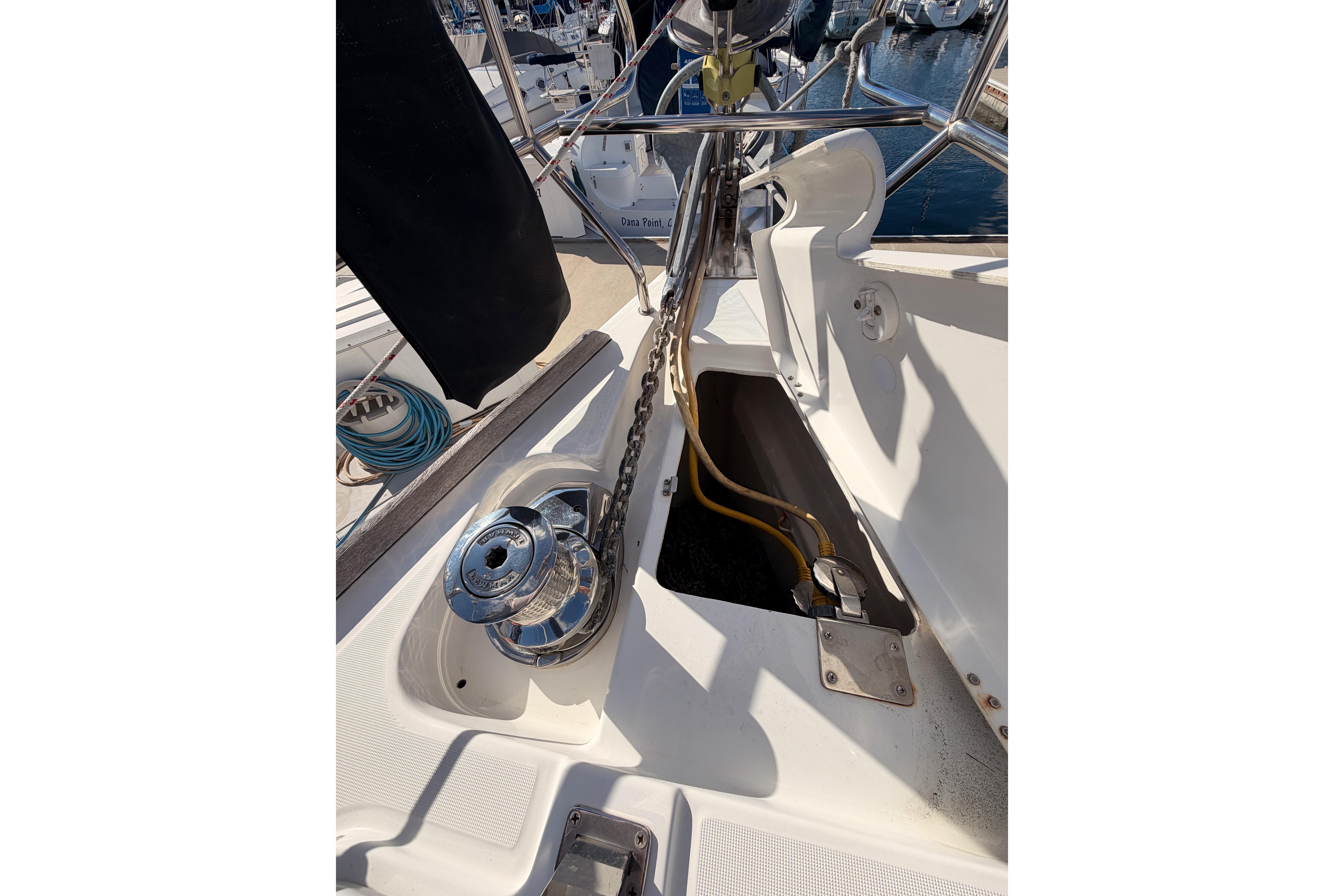 Deck view of a 2007 Beneteau 49 sailboat, featuring anchor chain and winch.