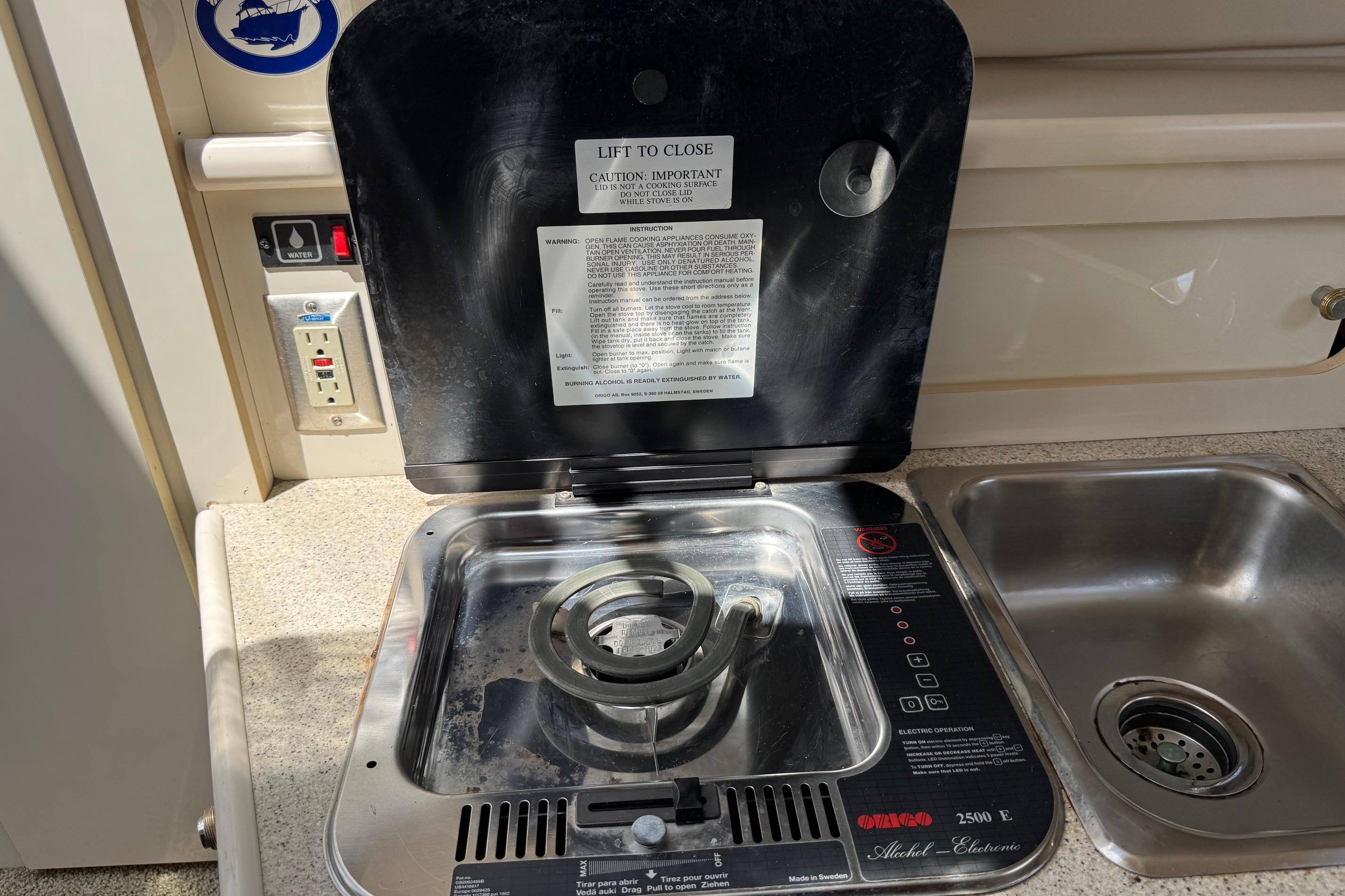 Boat kitchen with stove and sink in a 2000 Maxum 2400 SCR model.