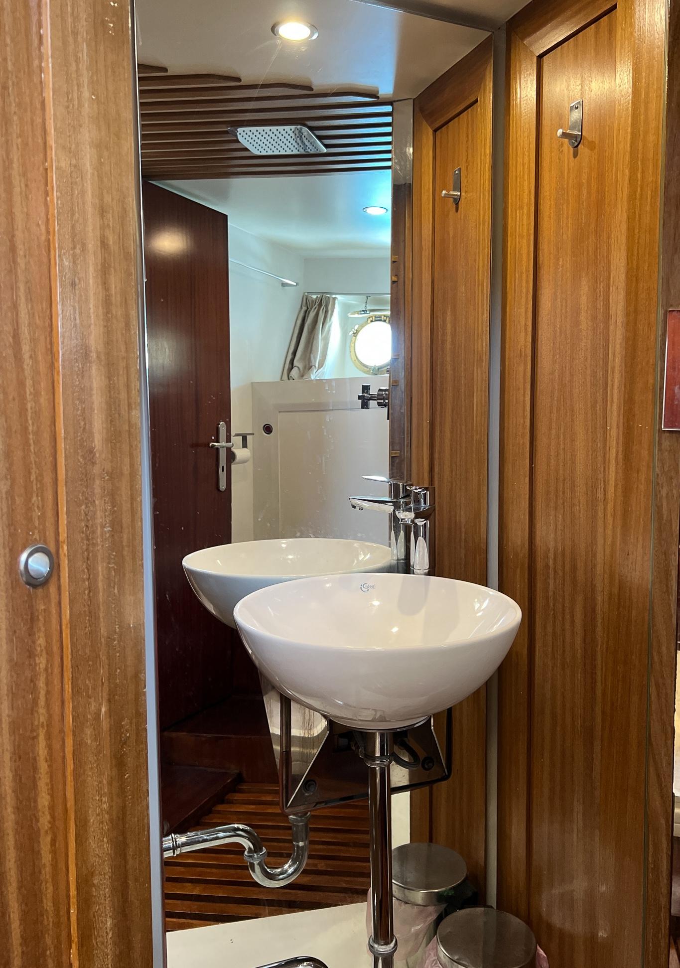 Wood-paneled bathroom with modern sink on 1969 Psarros Shipyard custom boat.