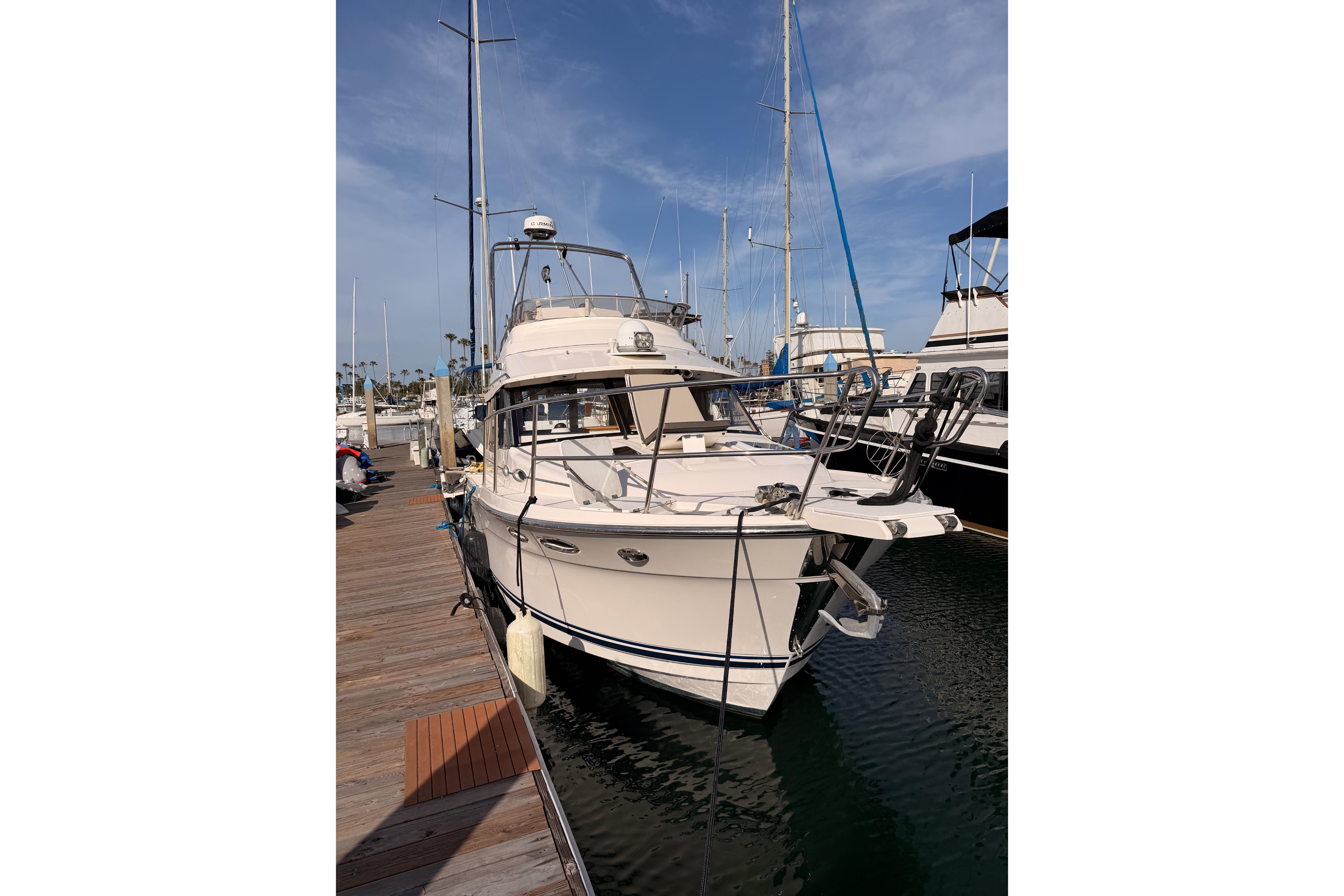 2021 Cutwater C-32 CB boat docked at a marina under a clear sky.