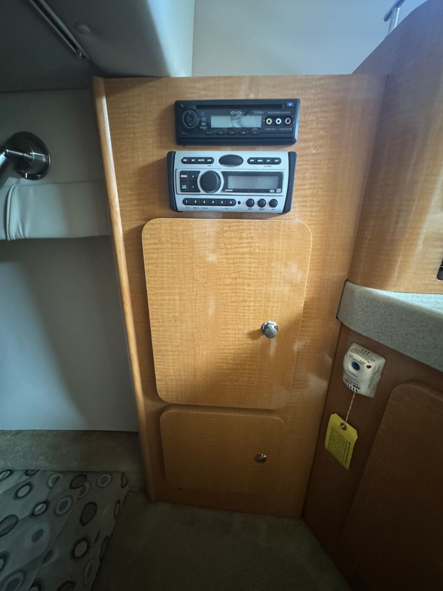 Interior of a boat with wood paneling and a stereo system.