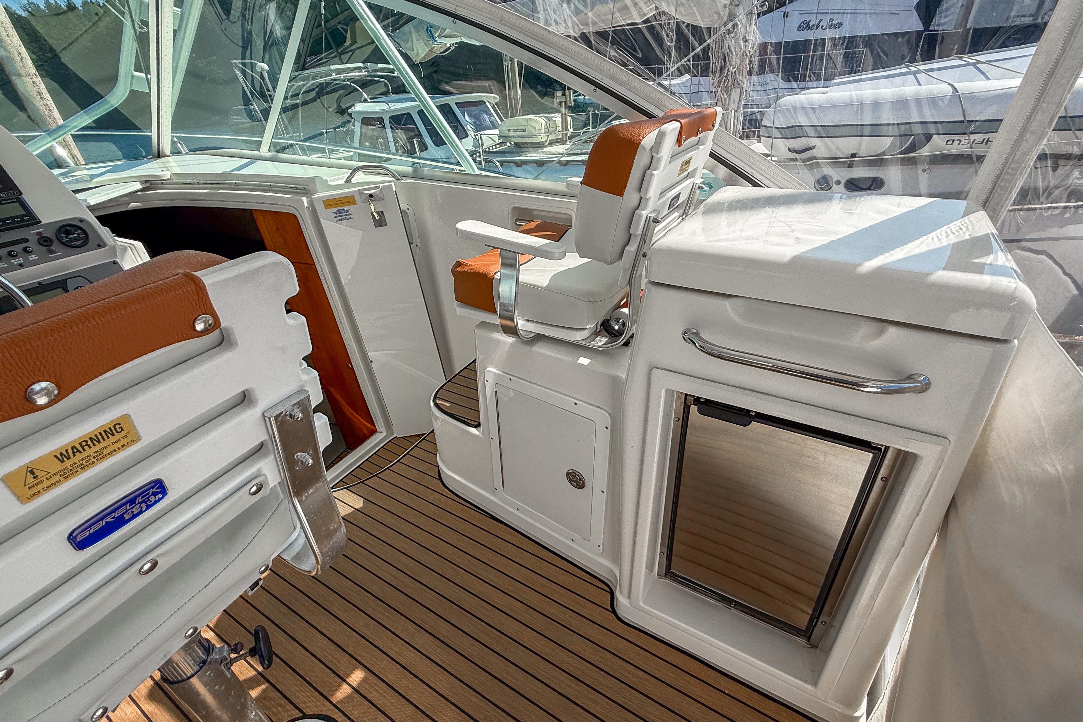 2005 Rampage 33 Express boat interior with seating and storage, featuring wood flooring.