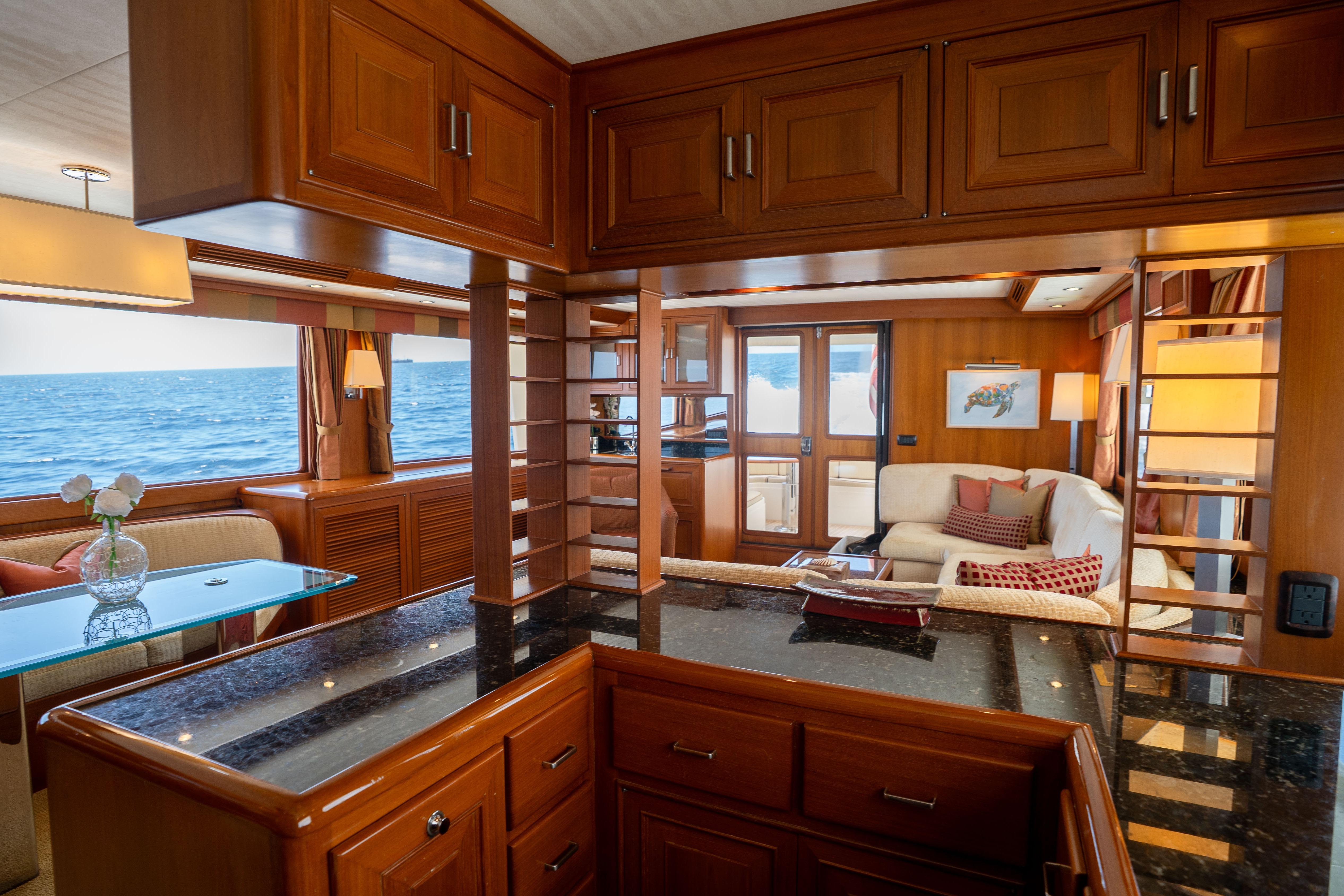 Luxurious interior of 2006 Fleming 75 yacht with ocean view and elegant wood finishes.