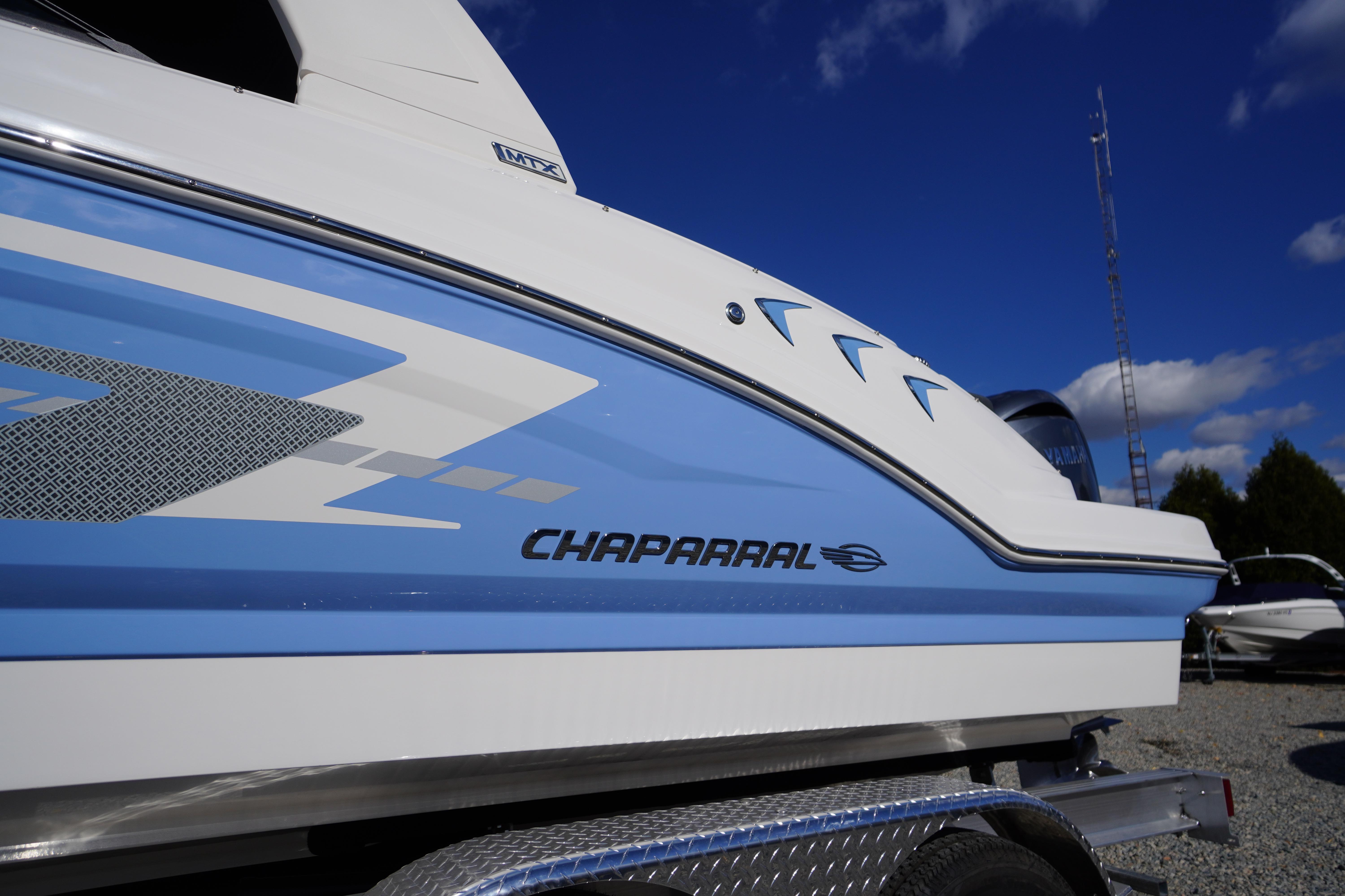 2026 Chaparral 23 SSi OB boat side view with blue and white design.