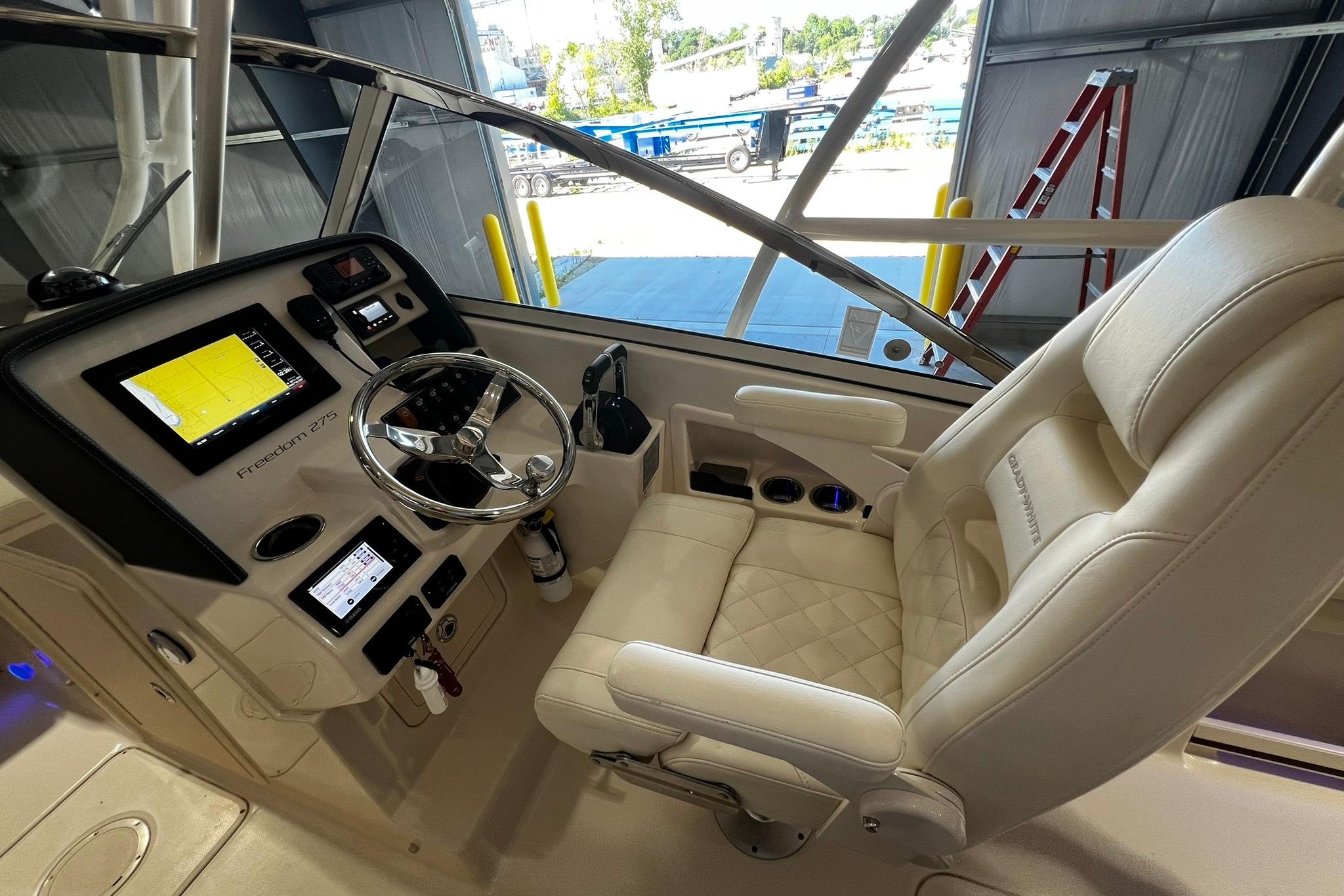 2014 Grady-White Freedom 275 boat cockpit with steering wheel and navigation screens.