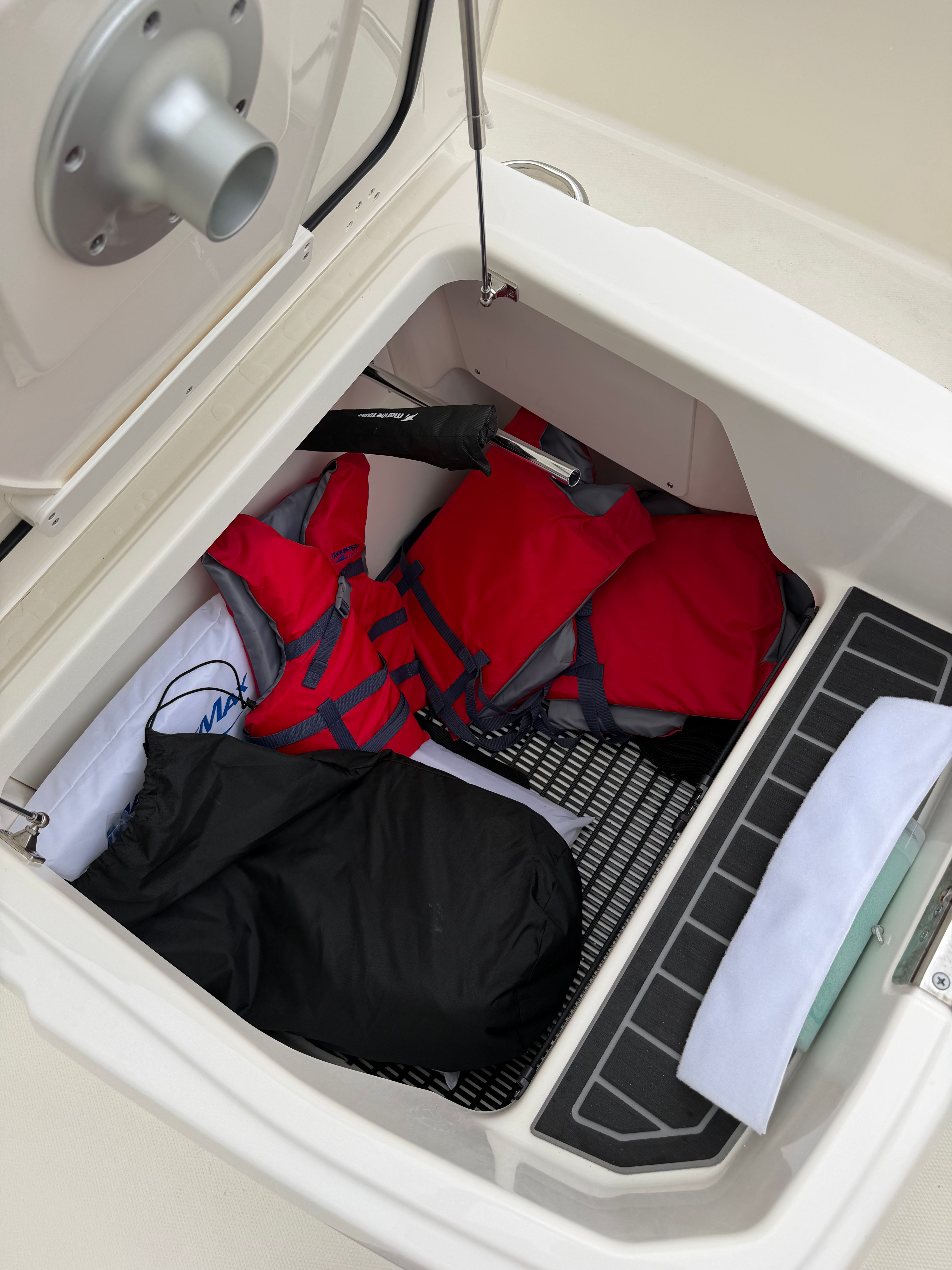 Storage compartment with life jackets and gear on a Boston Whaler 220 Dauntless.