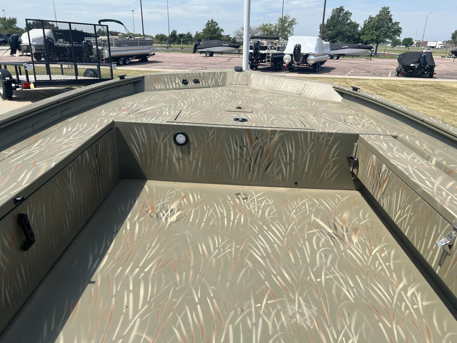 2025 Tracker Grizzly 1654 T Sportsman boat interior with camouflage design in a parking lot.