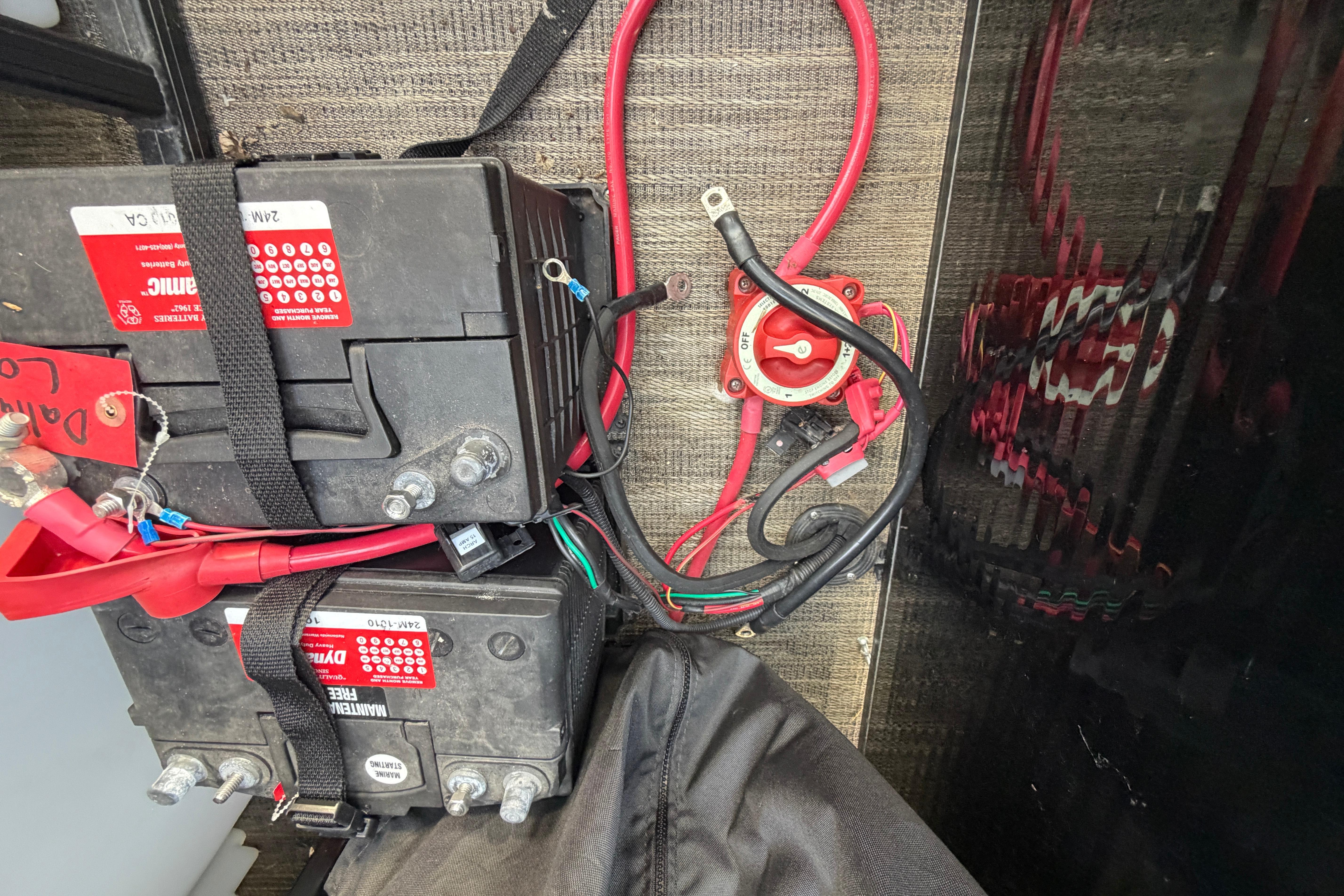 Battery setup in a 2023 Godfrey Sweetwater 2286 C boat, featuring wiring and connections.