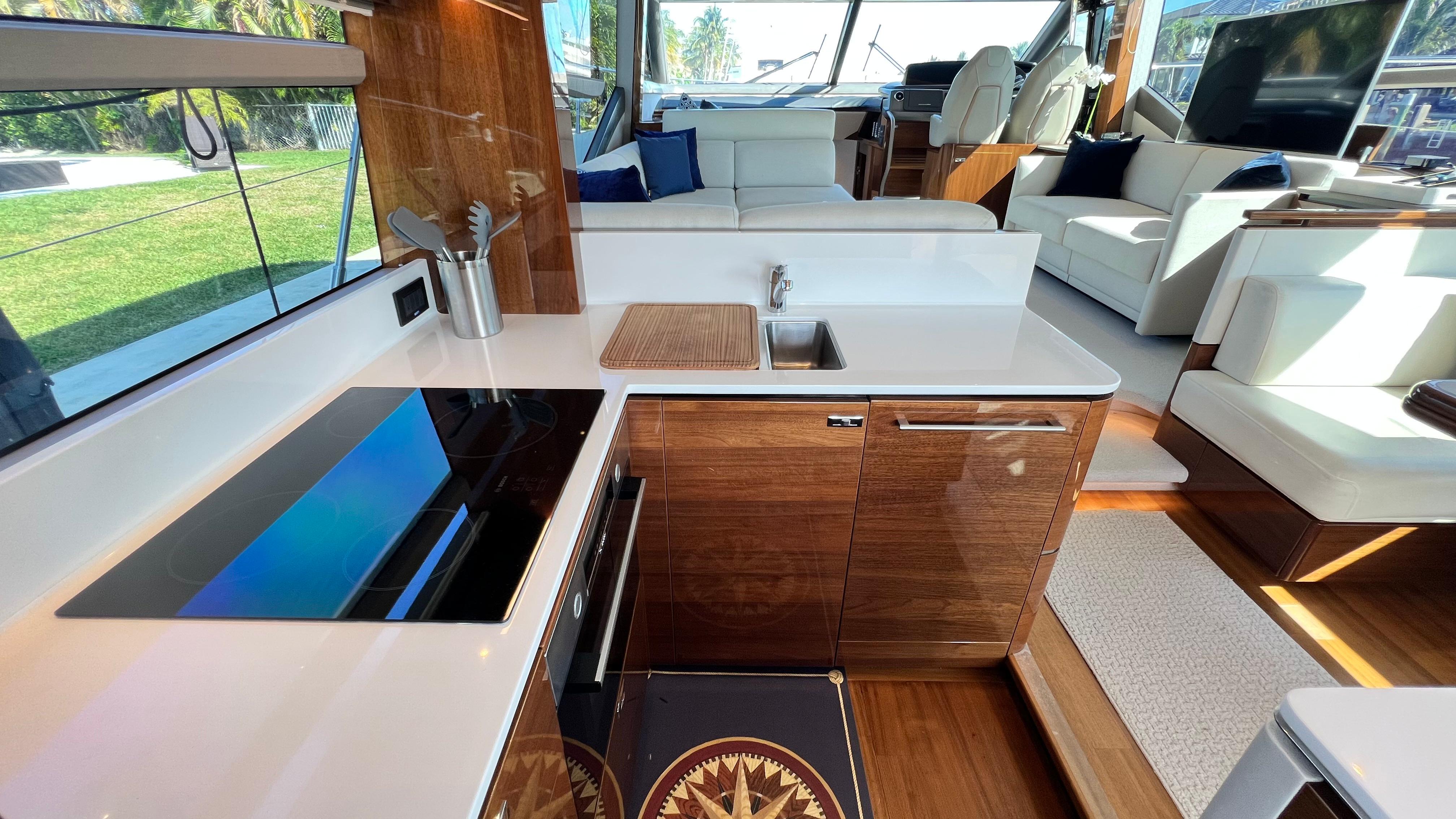 Luxurious interior of 2019 Princess F62 yacht with modern kitchen and seating area.