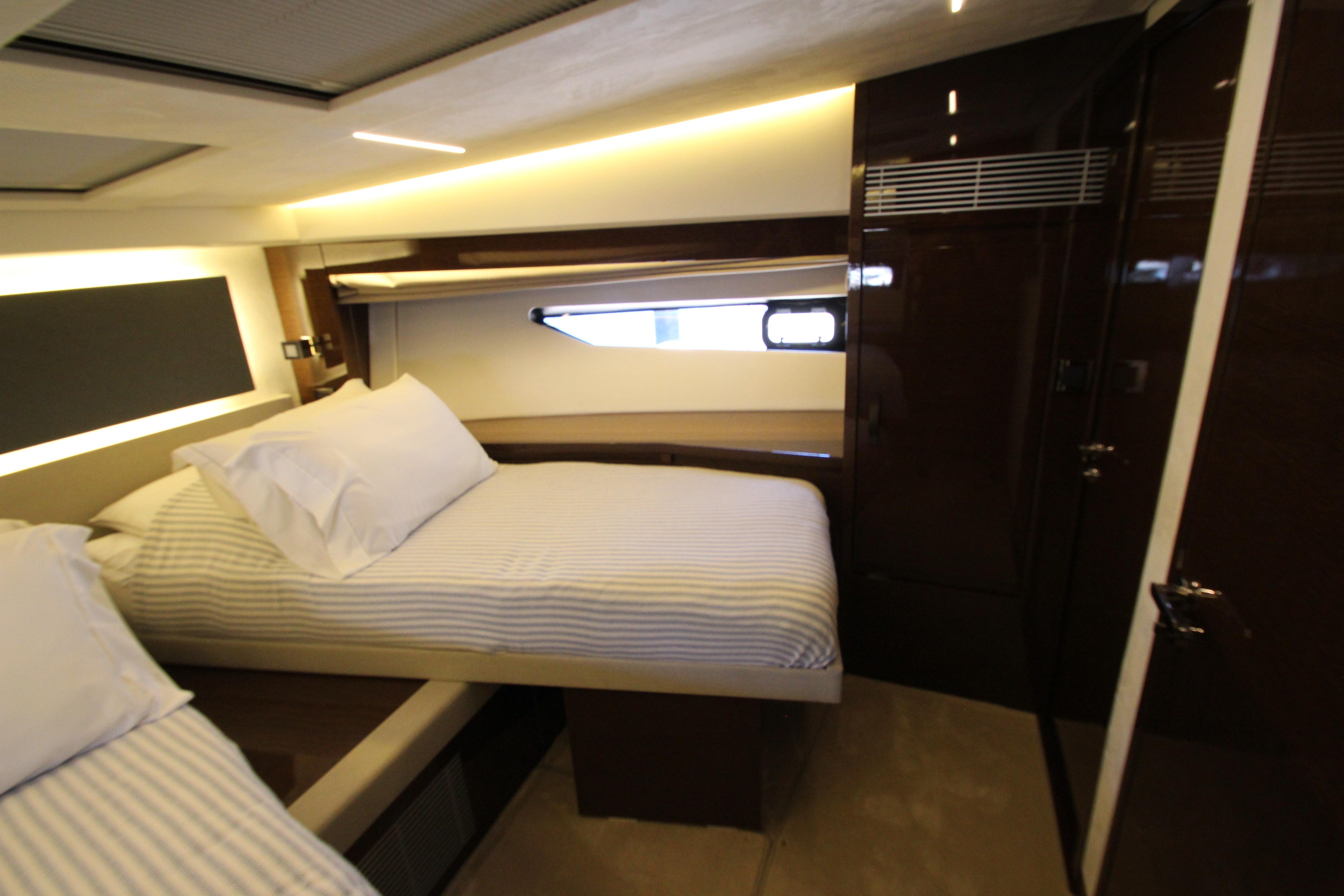 Luxurious cabin interior of 2022 Prestige 520 yacht with twin beds and modern design.