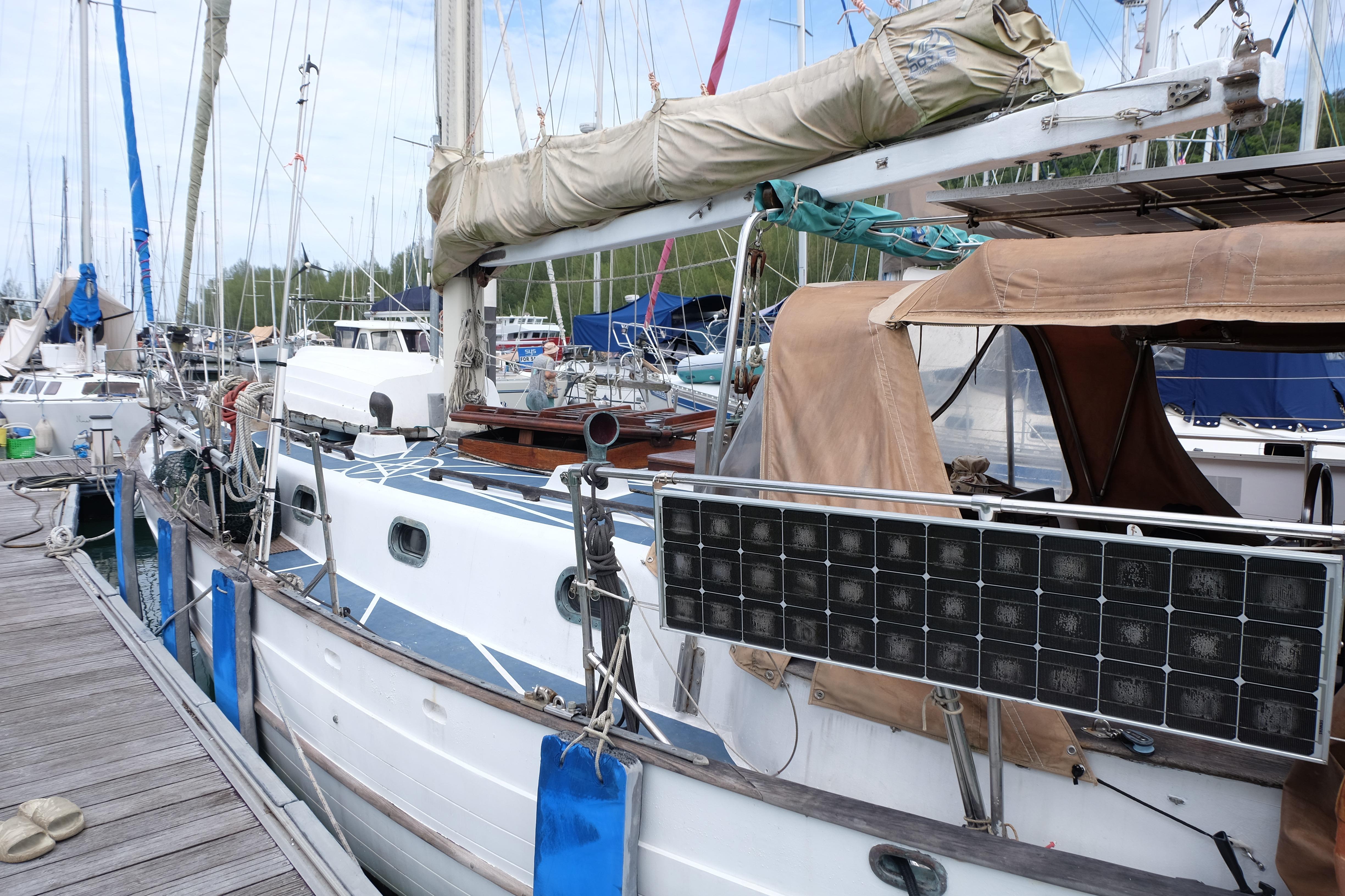 1979 Westwind 35 sailboat docked with solar panels and covered sails.