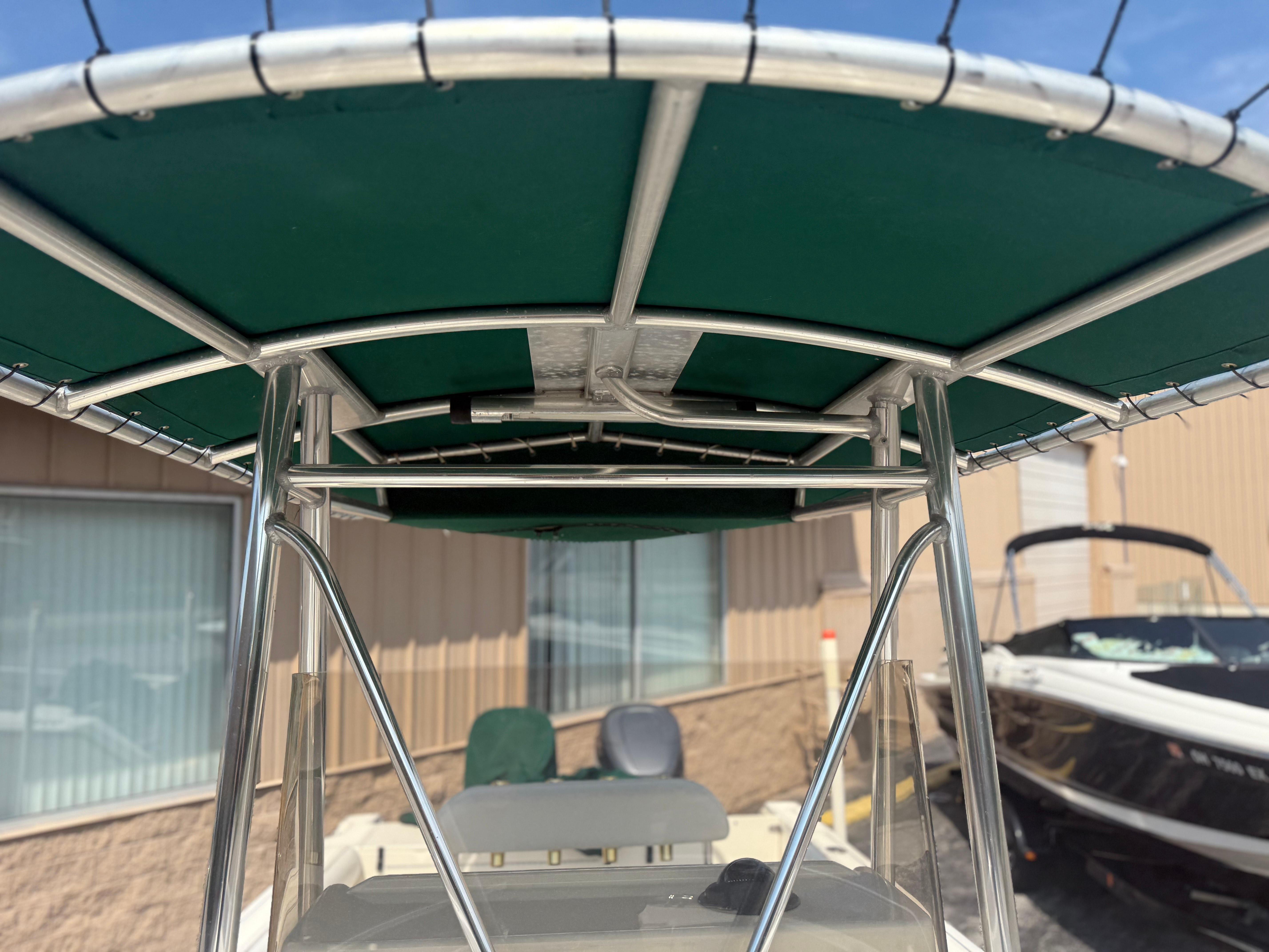 2002 Pursuit 2470 CC boat with green T-top canopy and stainless steel frame.