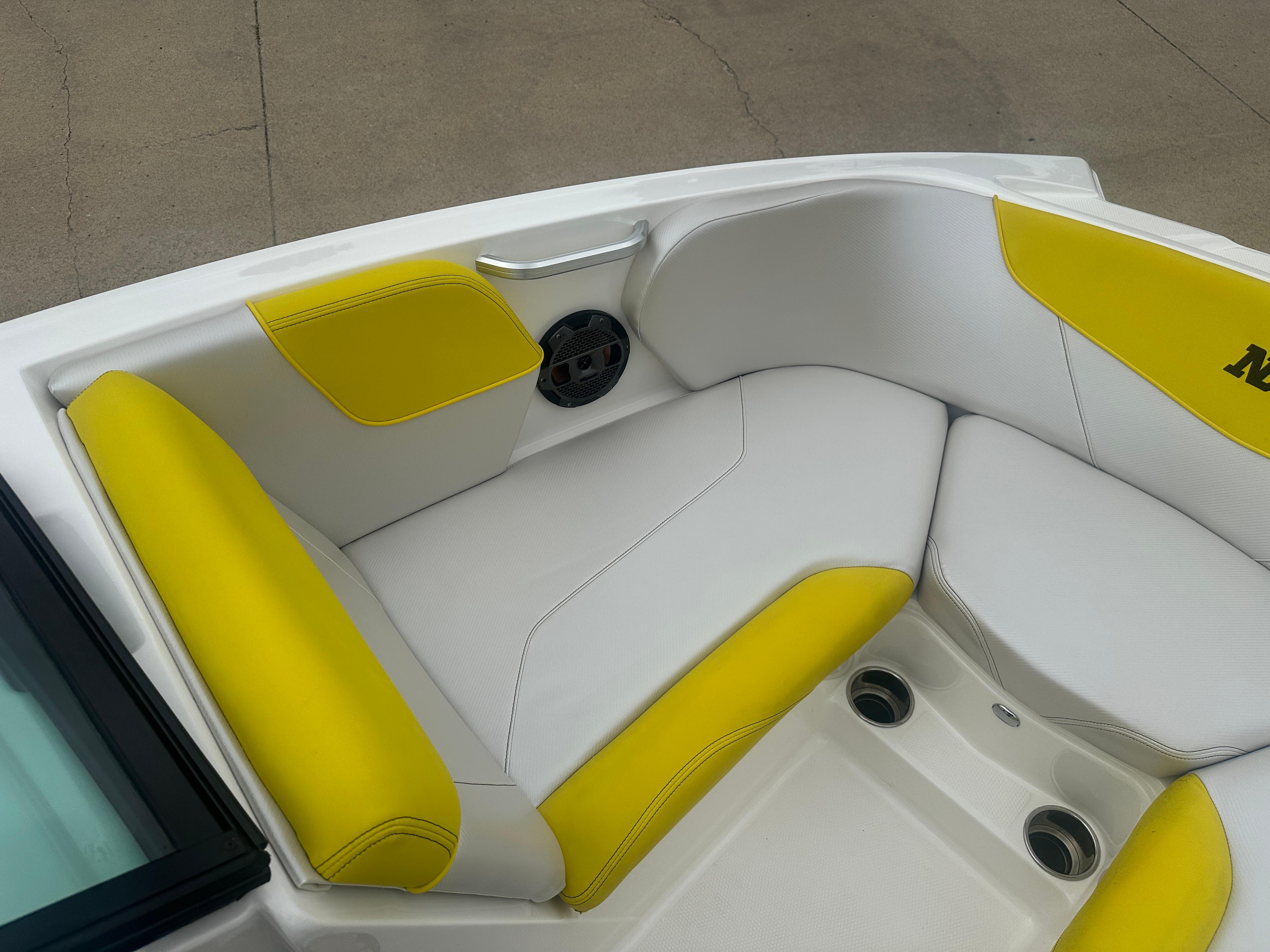 2018 MasterCraft NXT22 boat interior with yellow and white seating, featuring cup holders and speaker.