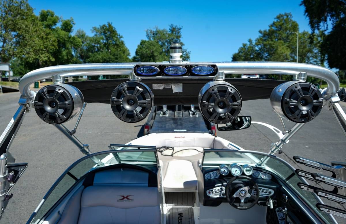 The image shows the cockpit of a MasterCraft X-45 boat with speakers and a control console.