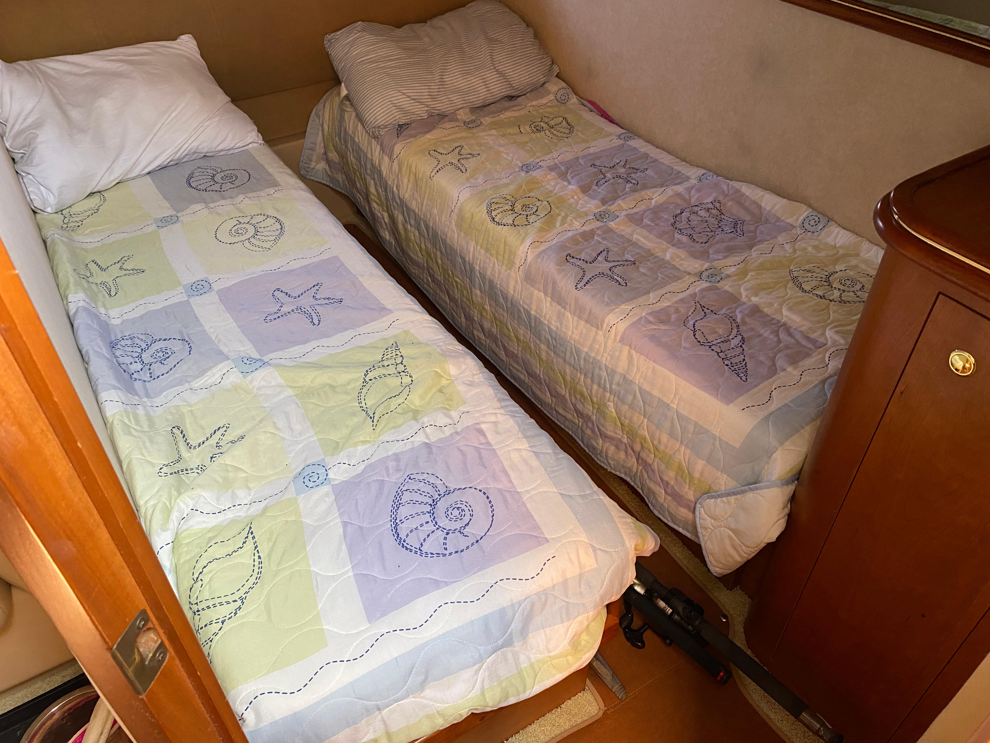 Twin beds with seashell-themed bedding in a 2000 Cruisers 3672 cabin.