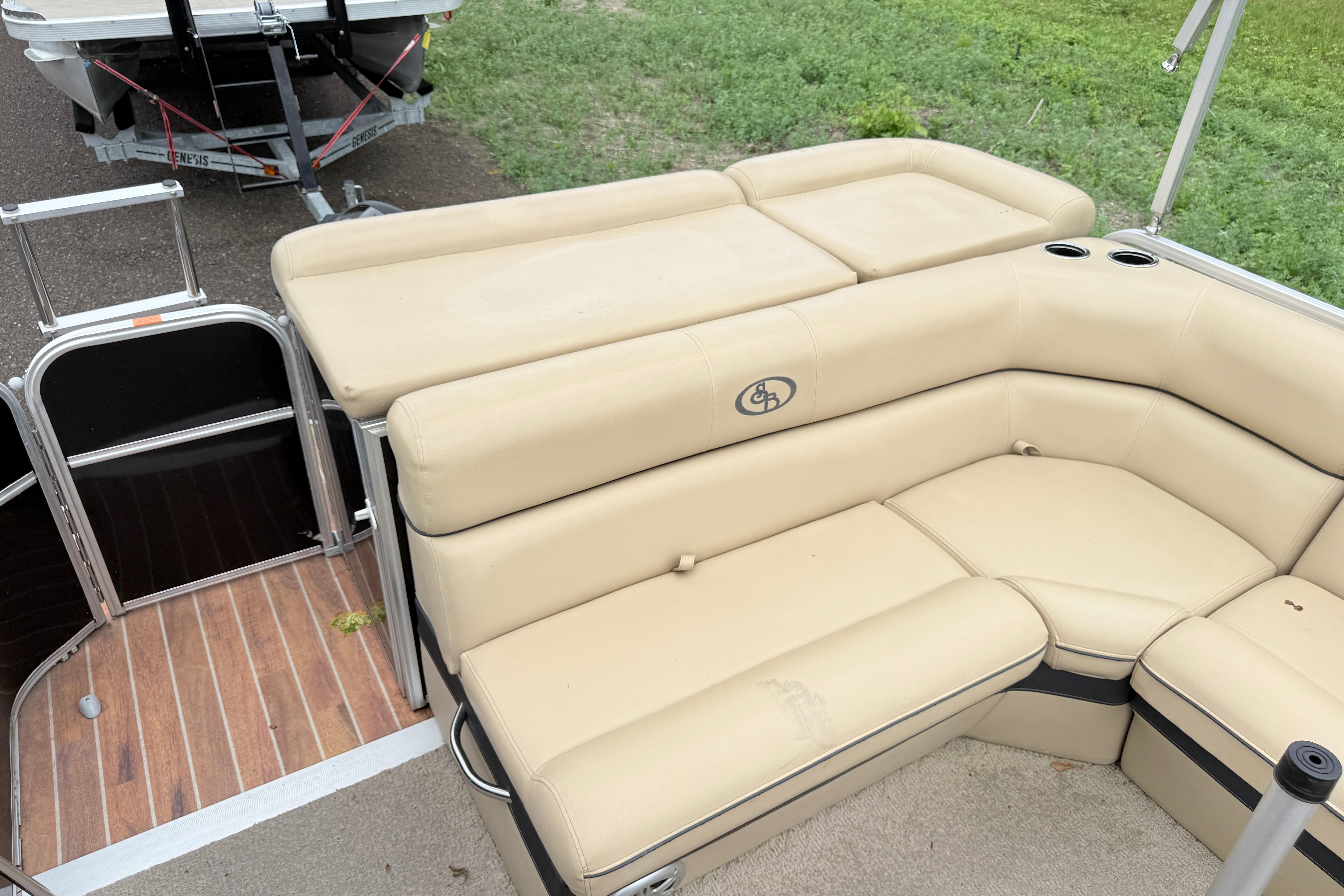 2013 South Bay 522CR pontoon boat with beige seating and cup holders.