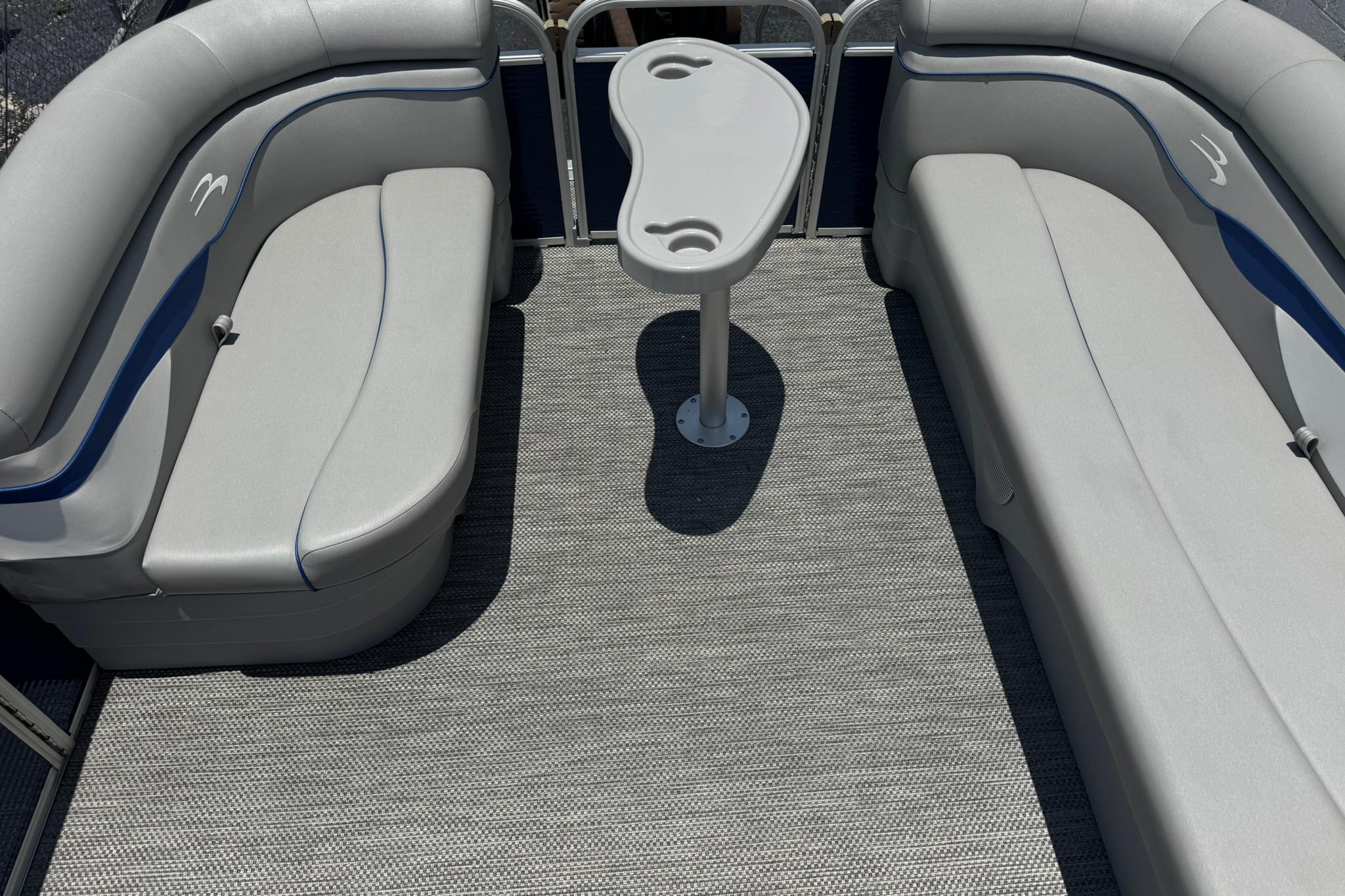 2024 Bennington SV 168 SLV pontoon interior with gray seating and central table.