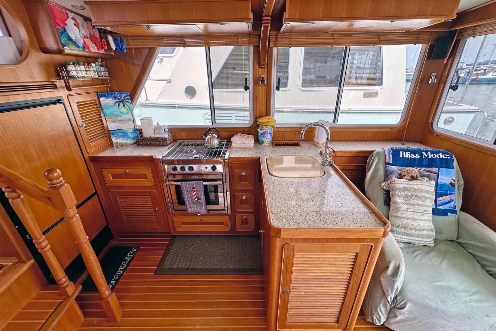 Cozy 2016 Helmsman Trawlers 38 Pilothouse interior with kitchen and seating area.