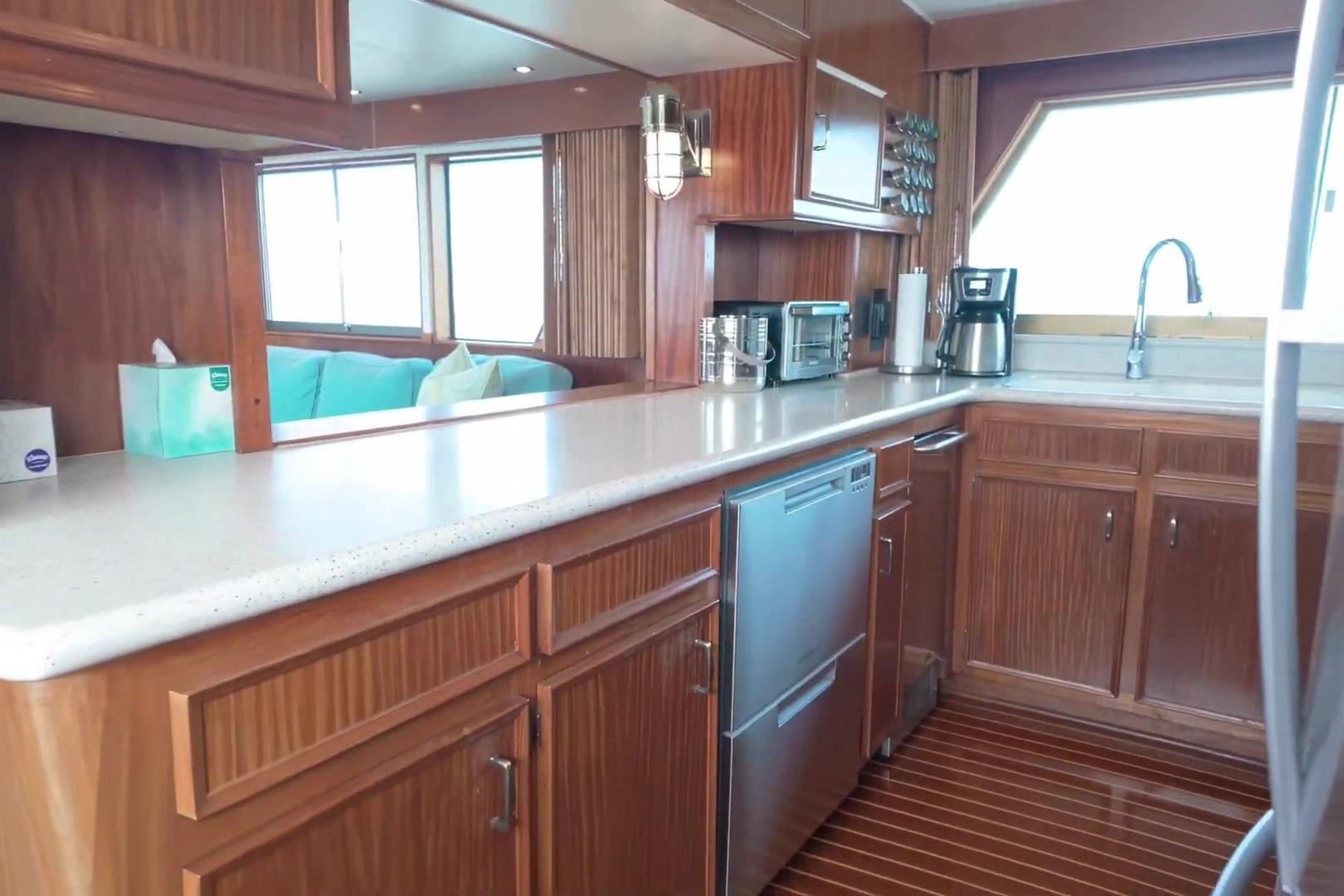Interior of 1980 Hatteras 70 Motor Yacht kitchen with wood cabinetry and modern appliances.