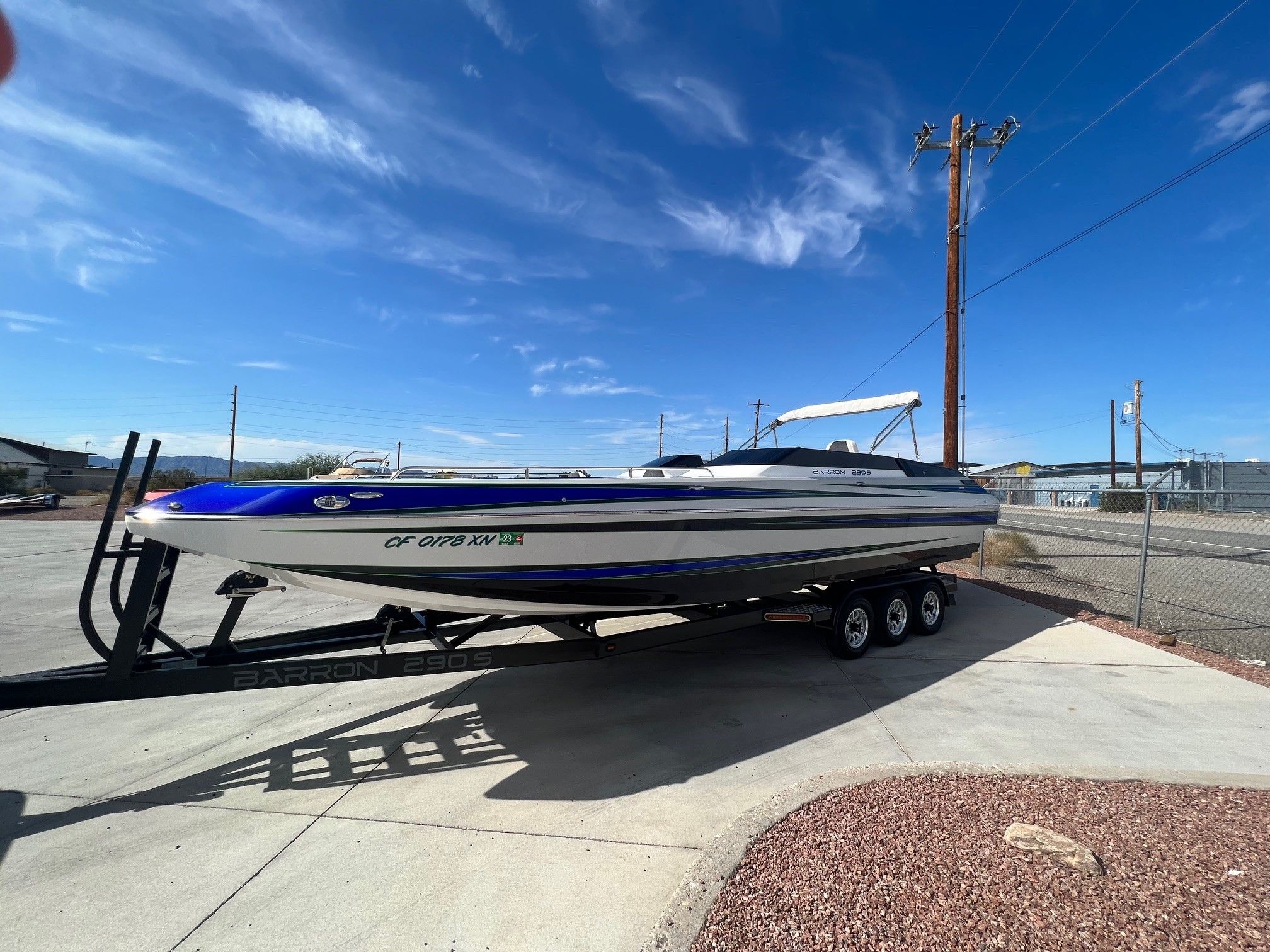 Custom Barron 290s boat from 2021 on trailer under blue sky.