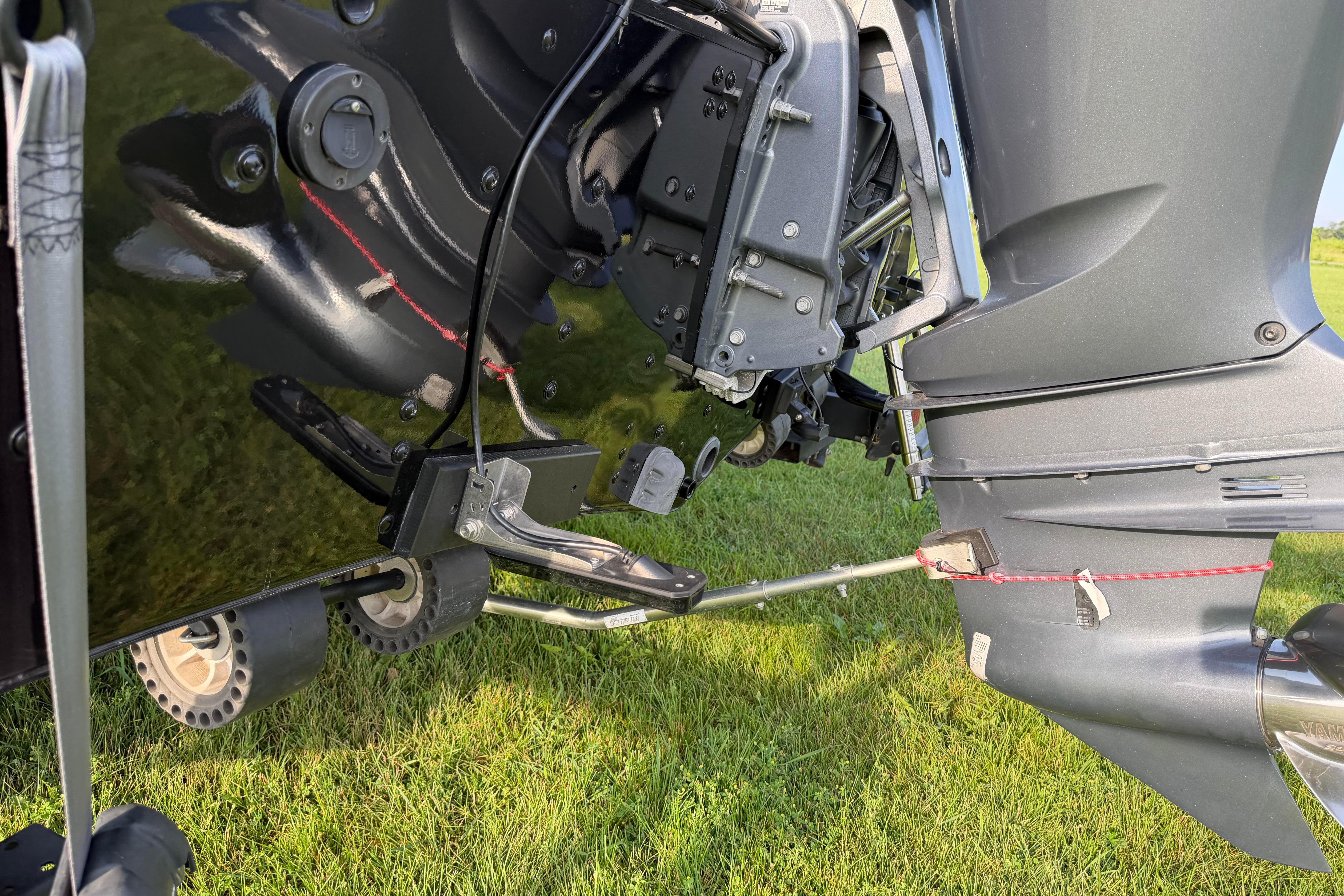 2019 Alumacraft Trophy 205 boat motor and propeller on grassy field.